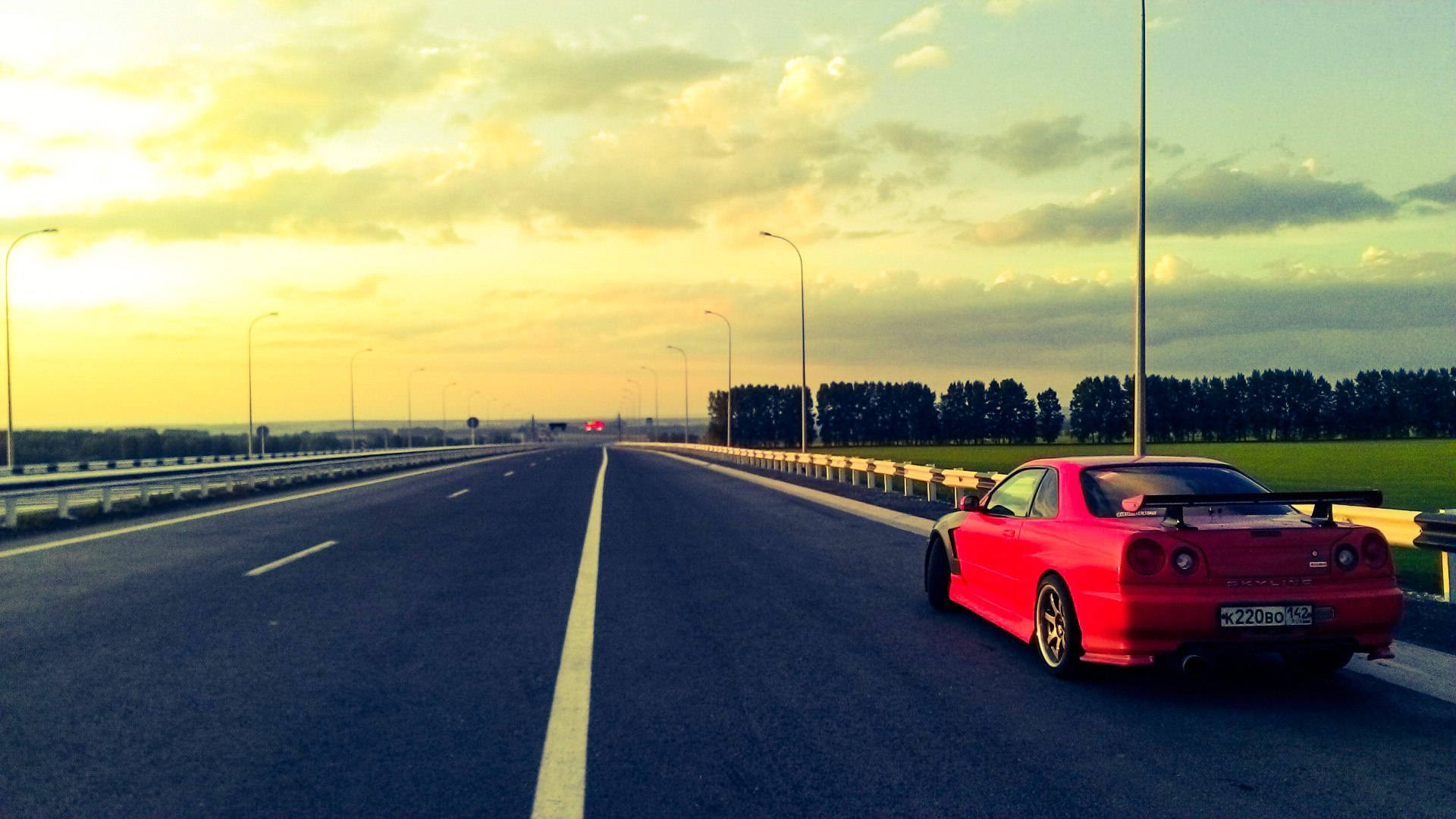 紅色跑車在金色日落時停泊在高速公路上。 — 日產 Skyline GTR R34 壁紙