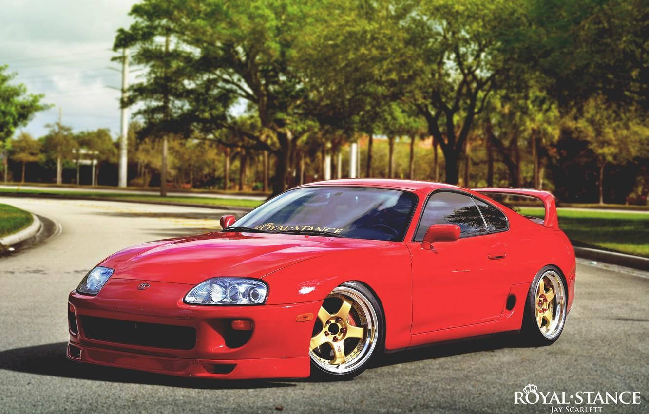 紅色豐田Supra配金色輪胎停放在綠樹成蔭的街道上。 — Toyota Supra 壁紙