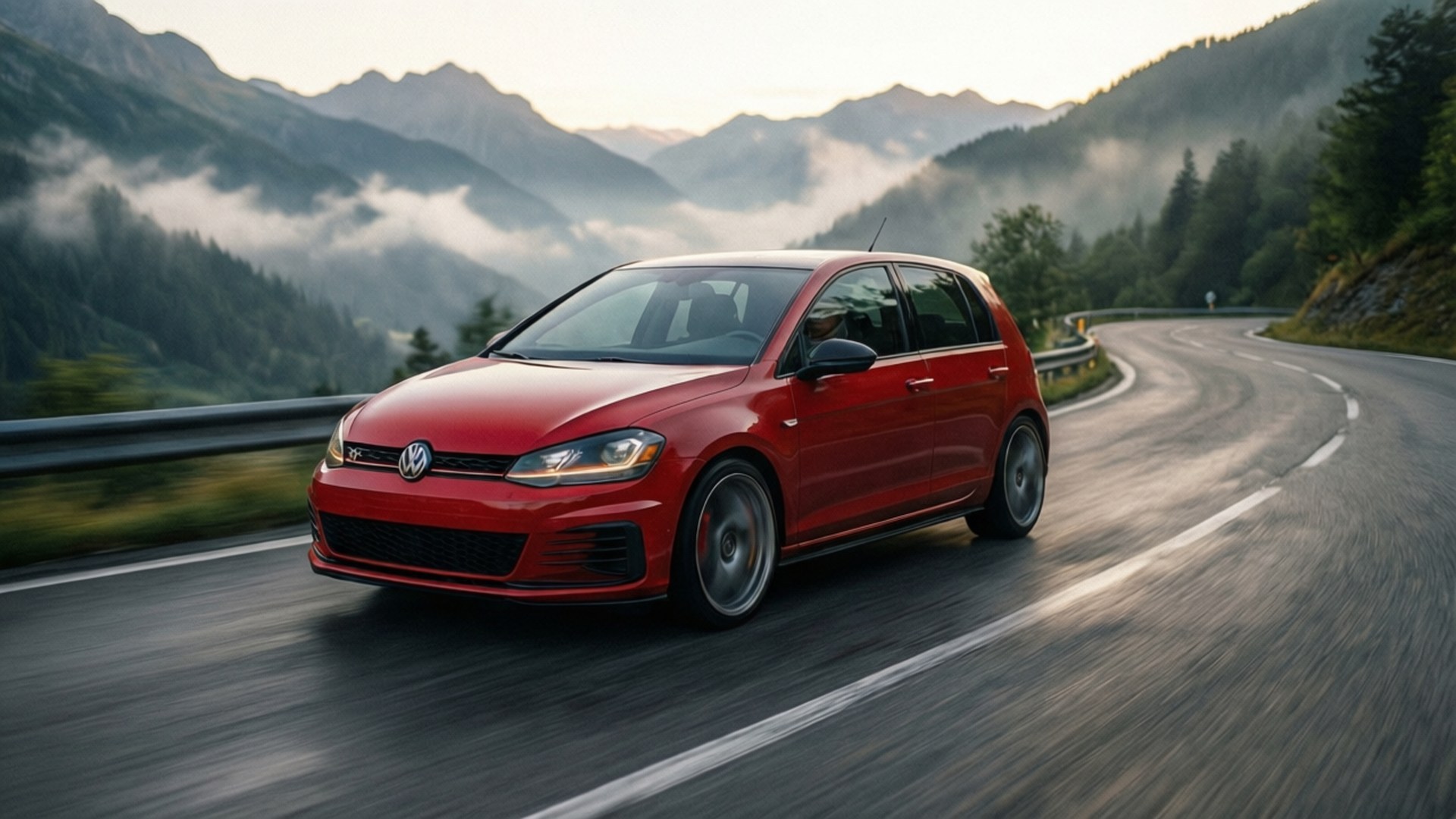 Mountain GTI Dawn 壁紙 — 一輛鮮紅色的福斯 Golf R 在蜿蜒的山路上奔馳，黎明時分霧氣在森林覆蓋的山峰間繚繞。