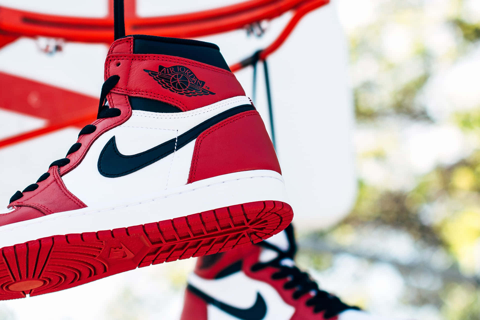 紅白黑色Air Jordan運動鞋掛在籃球框上。 — Air Jordan 壁紙