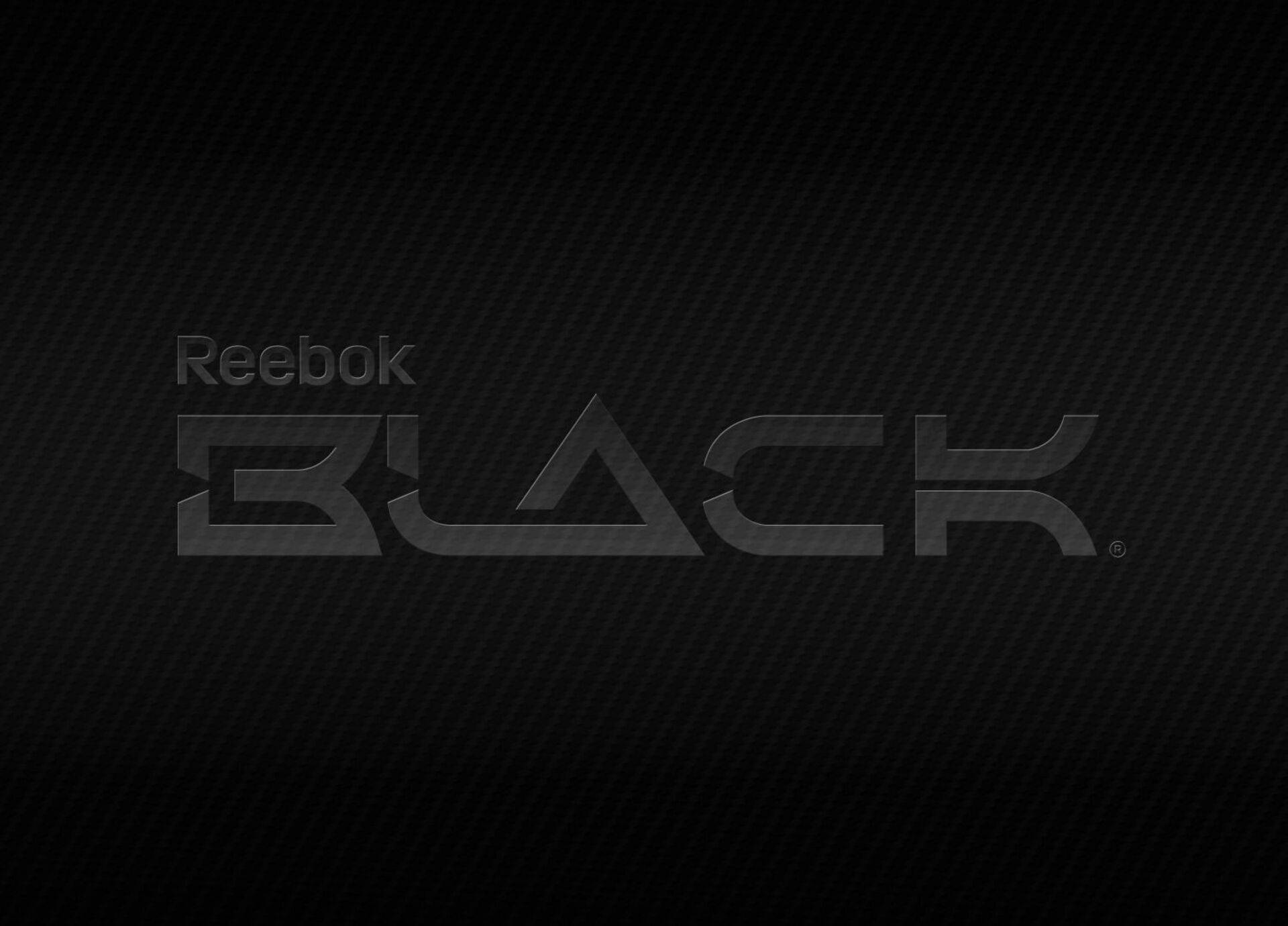 Reebok 桌布 壁紙 — Reebok BLACK 標誌以金屬灰色呈現於紋理黑色碳纖維背景上。