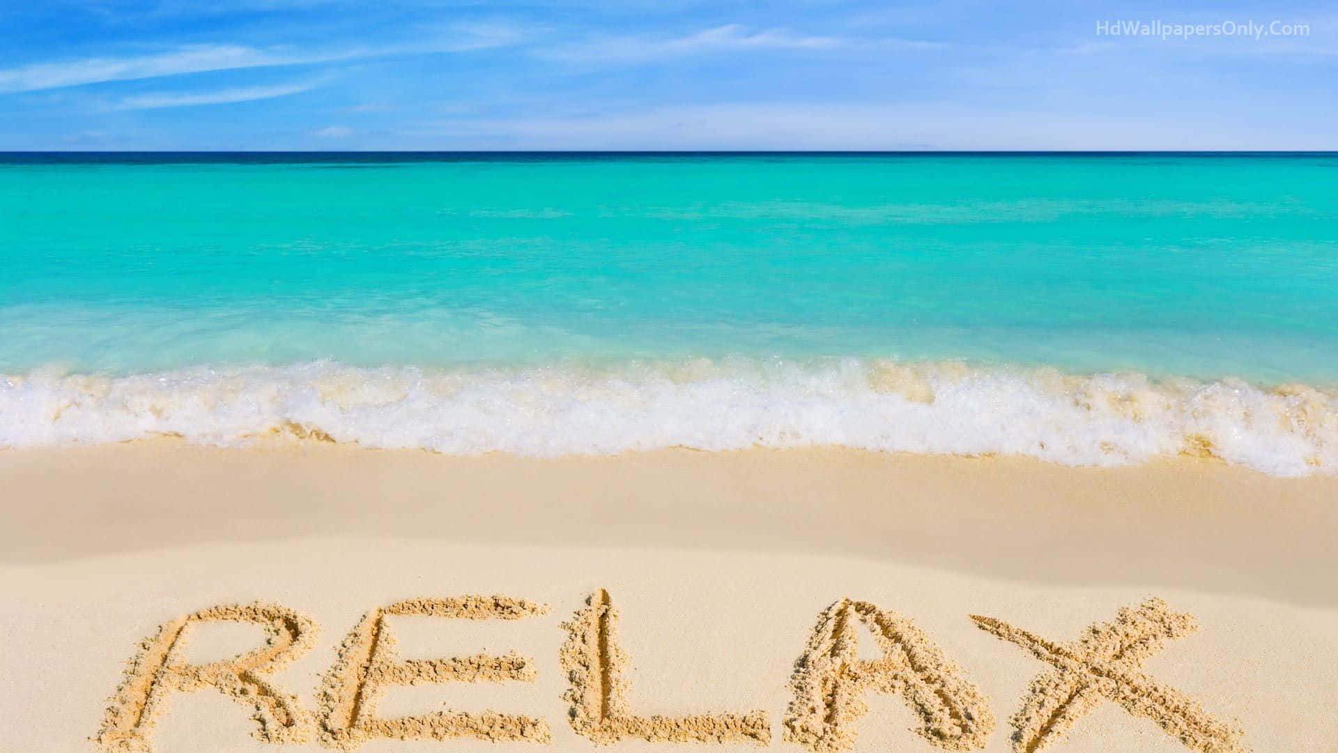 海灘 桌布 壁紙 — 「relax」這個字寫在一個純淨海灘的沙上，有青綠色海浪在晴朗藍天下翻滾。