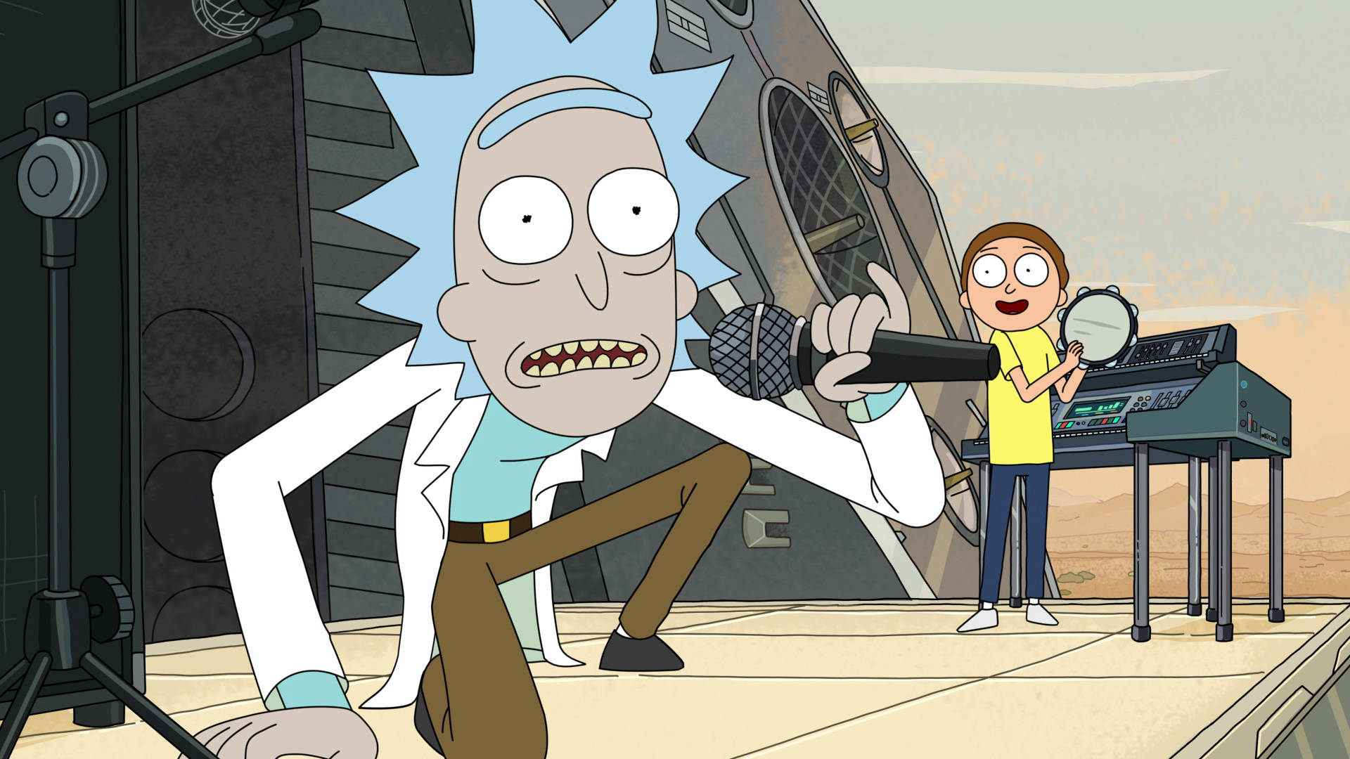 超殺的瑞克和莫蒂 桌布 壁紙 — Rick Sanchez 在沙漠舞台上熱情地對著麥克風唱歌，而 Morty 在他旁邊彈奏鍵盤。