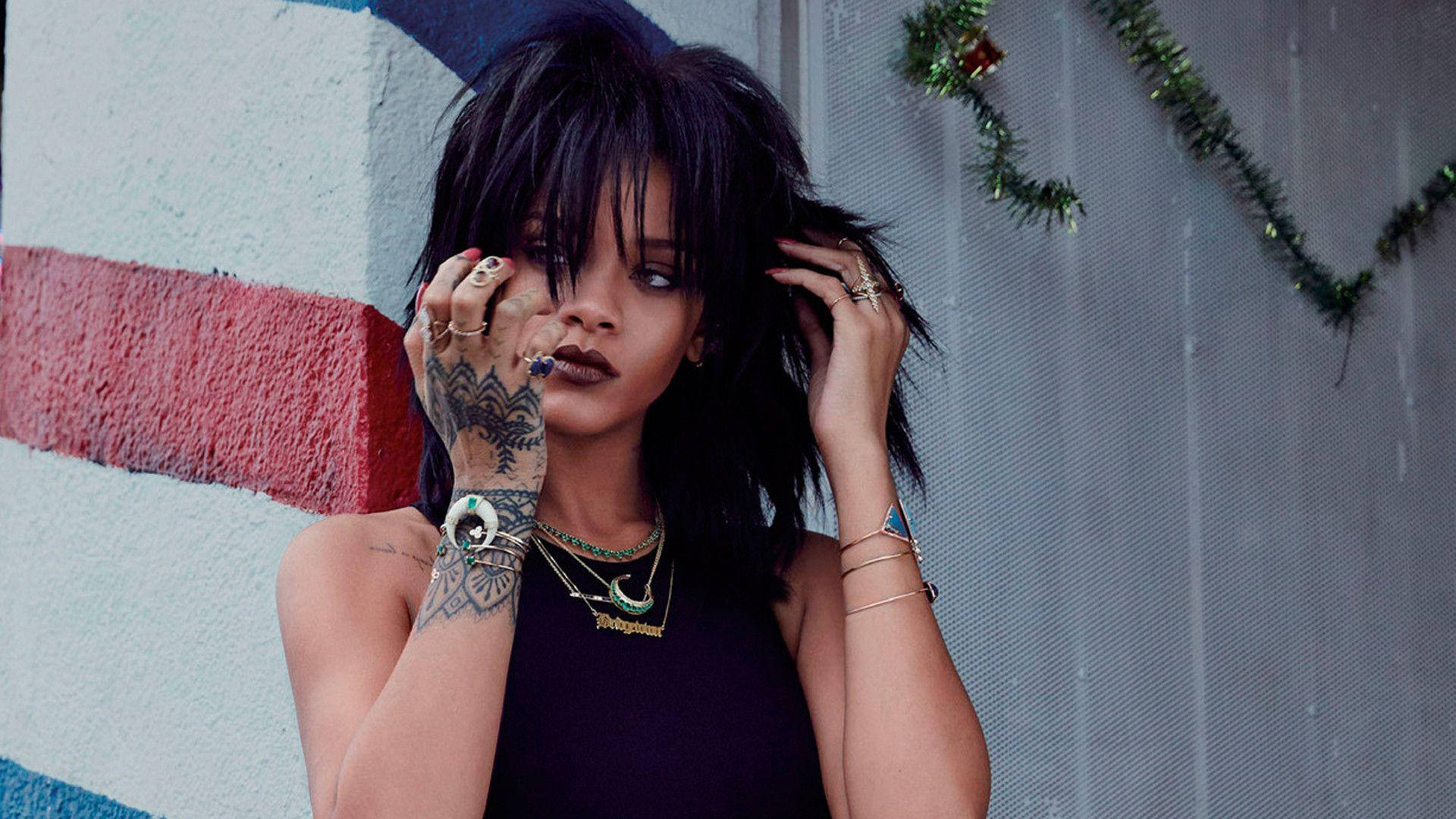 Celebrity 桌布 壁紙 — Rihanna 以深色頭髮和刺青，在條紋牆壁和節日花環前擺姿勢。