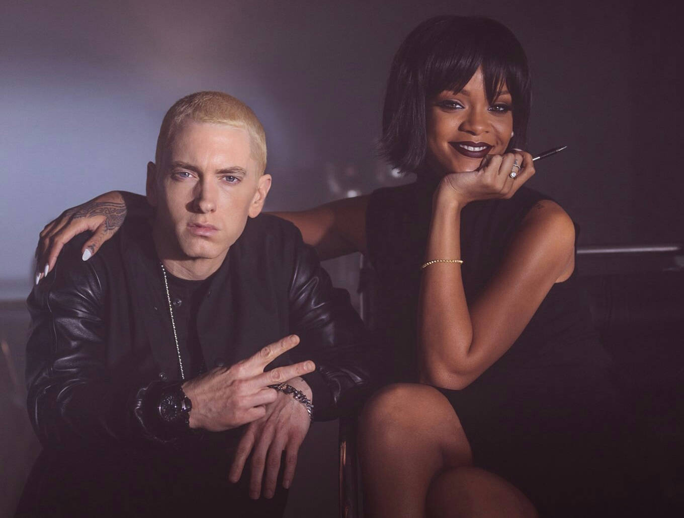 阿姆 桌布 壁紙 — Rihanna 和 Eminem 在燈光昏暗的攝影棚中自信地擺姿勢，帶有戲劇性的燈光和暗色調。