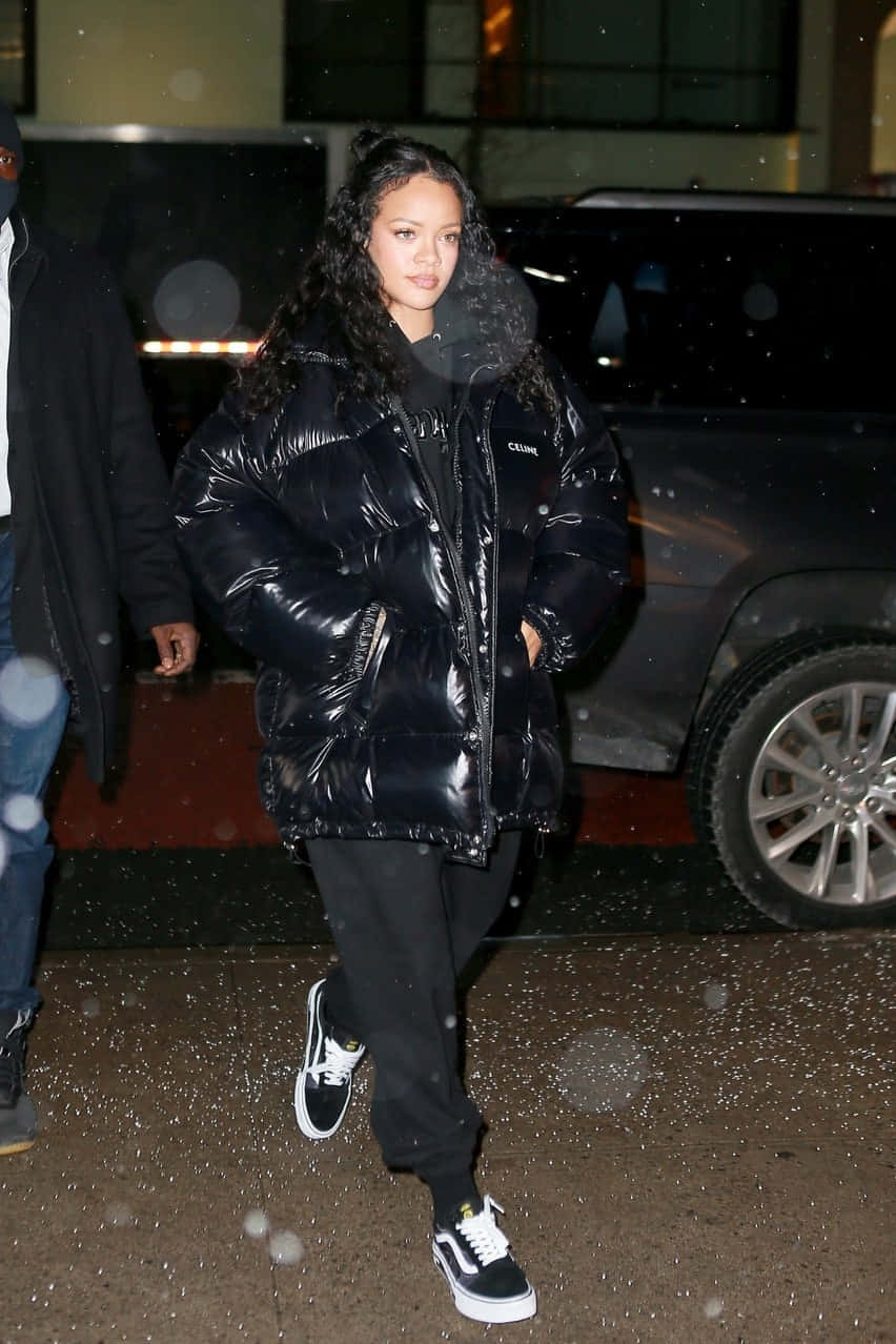 Vans 桌布 壁紙 — Rihanna 在夜晚雪中穿著黑色羽絨外套和運動鞋在戶外行走。