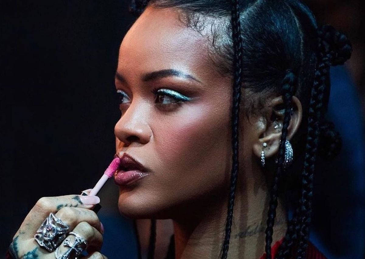 Fenty 桌布 壁紙 — Rihanna 在深色背景下塗上粉紅色唇彩，搭配閃亮眼妝和辮子頭髮。