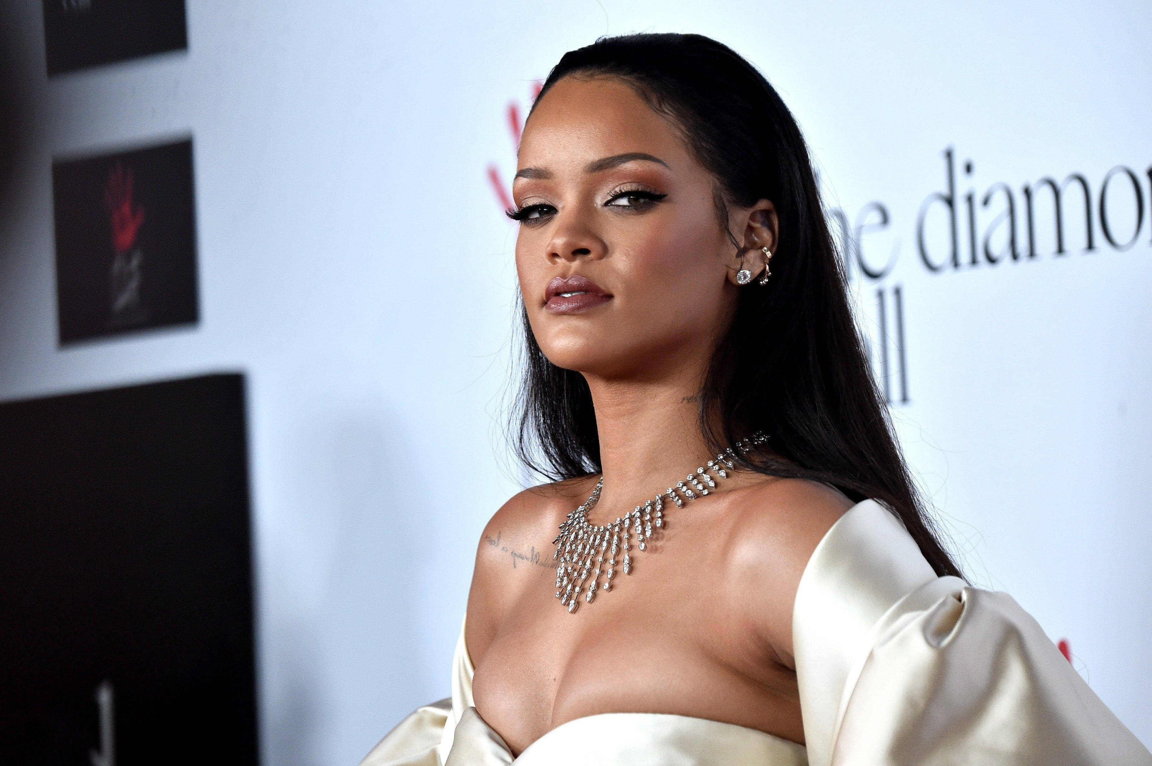 Celebrity 桌布 壁紙 — Rihanna 在紅地毯活動中，身穿奶油色緞面禮服，佩戴閃閃發光的鑽石項鍊，優雅地擺姿勢。