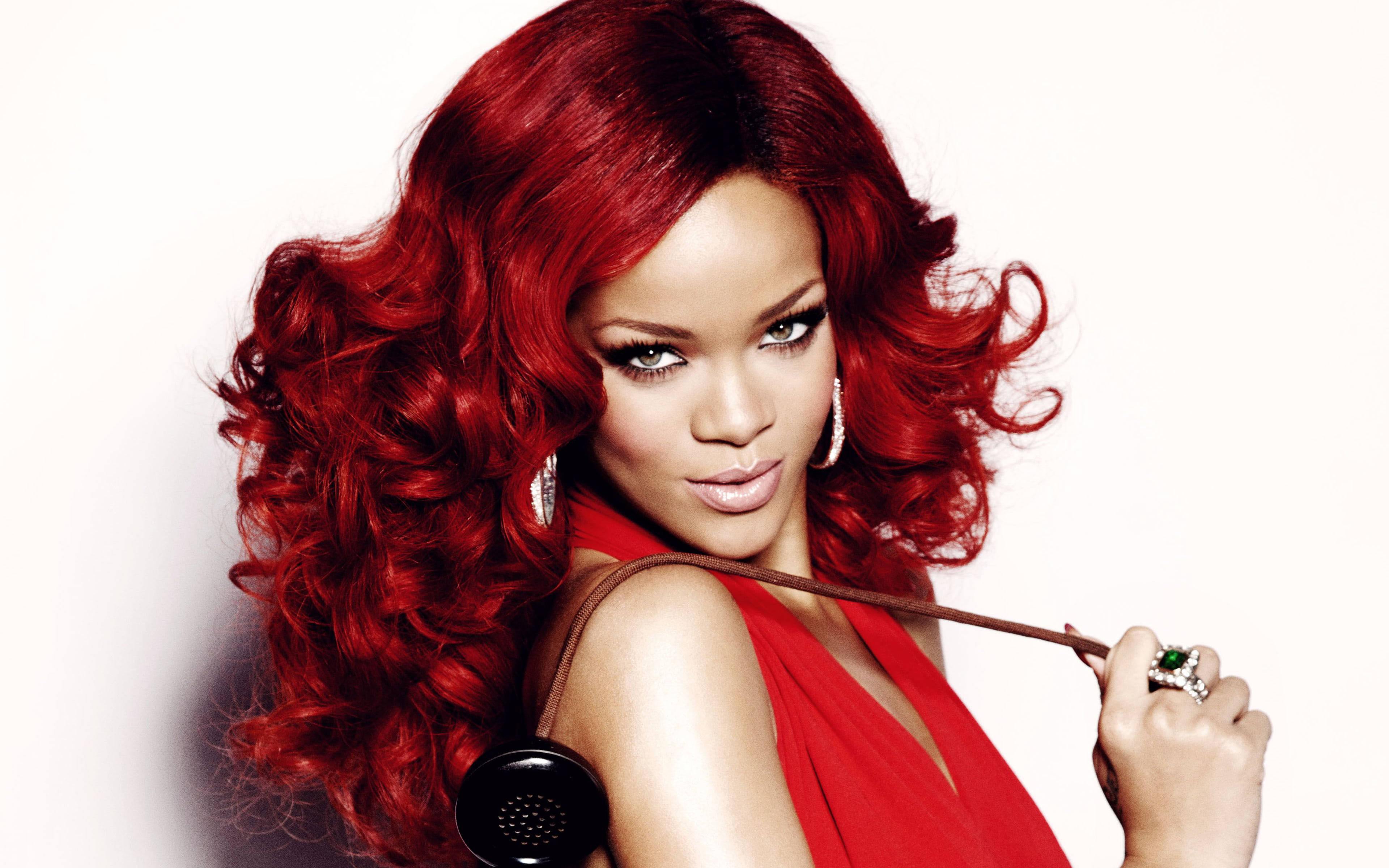 Singer 桌布 壁紙 — Rihanna 擁有火紅捲髮和鮮豔妝容，在純白背景前拿著一部復古電話。