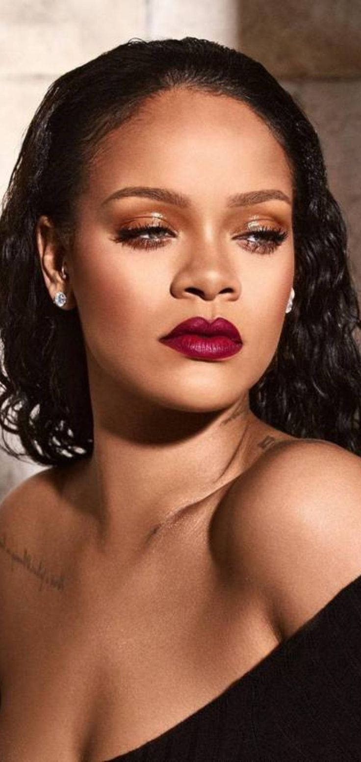 Fenty 桌布 壁紙 — Rihanna 擁有鮮豔紅唇和閃爍雙眼，在紋理石牆背景下溫柔凝視。