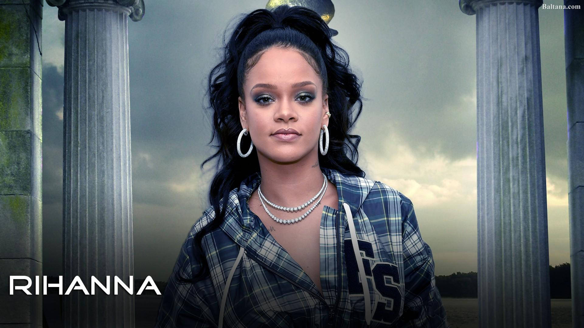 Celebrity 桌布 壁紙 — Rihanna 自信地站在古老的石柱之間，陰沉多雲的天空下，穿著格紋連帽衫和珍珠首飾。