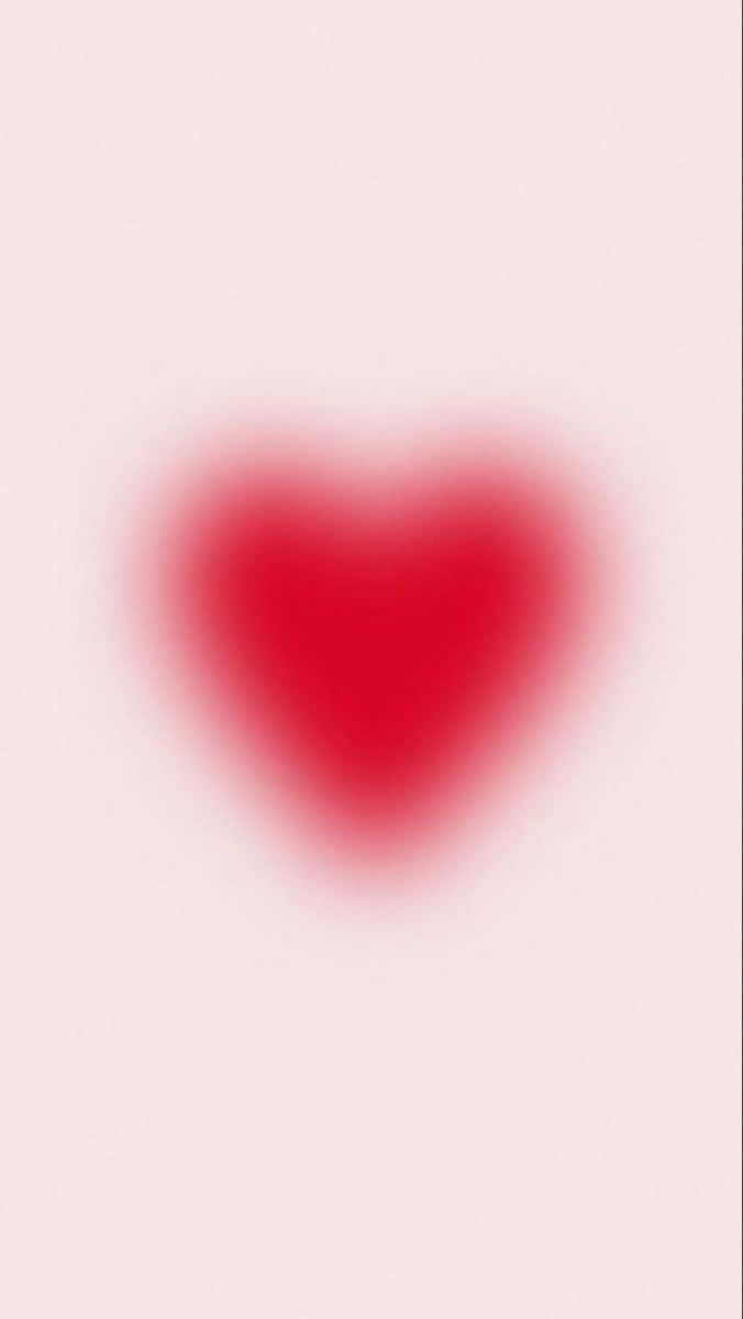 Pink Heart Aura 桌布 壁紙 — 一個柔和模糊的紅色心形置於淡粉紅色背景中央，營造出溫柔浪漫的氛圍。