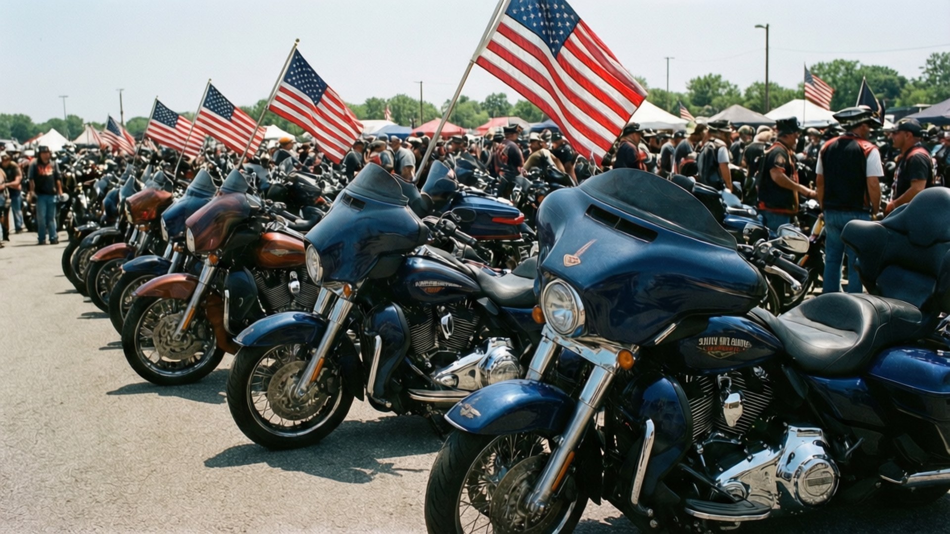 Biker Rally Gathering 壁紙 — 一排閃亮的藍色和鍍鉻哈雷戴維森摩托車停放在戶外，美國國旗在騎士人群上方飄揚。