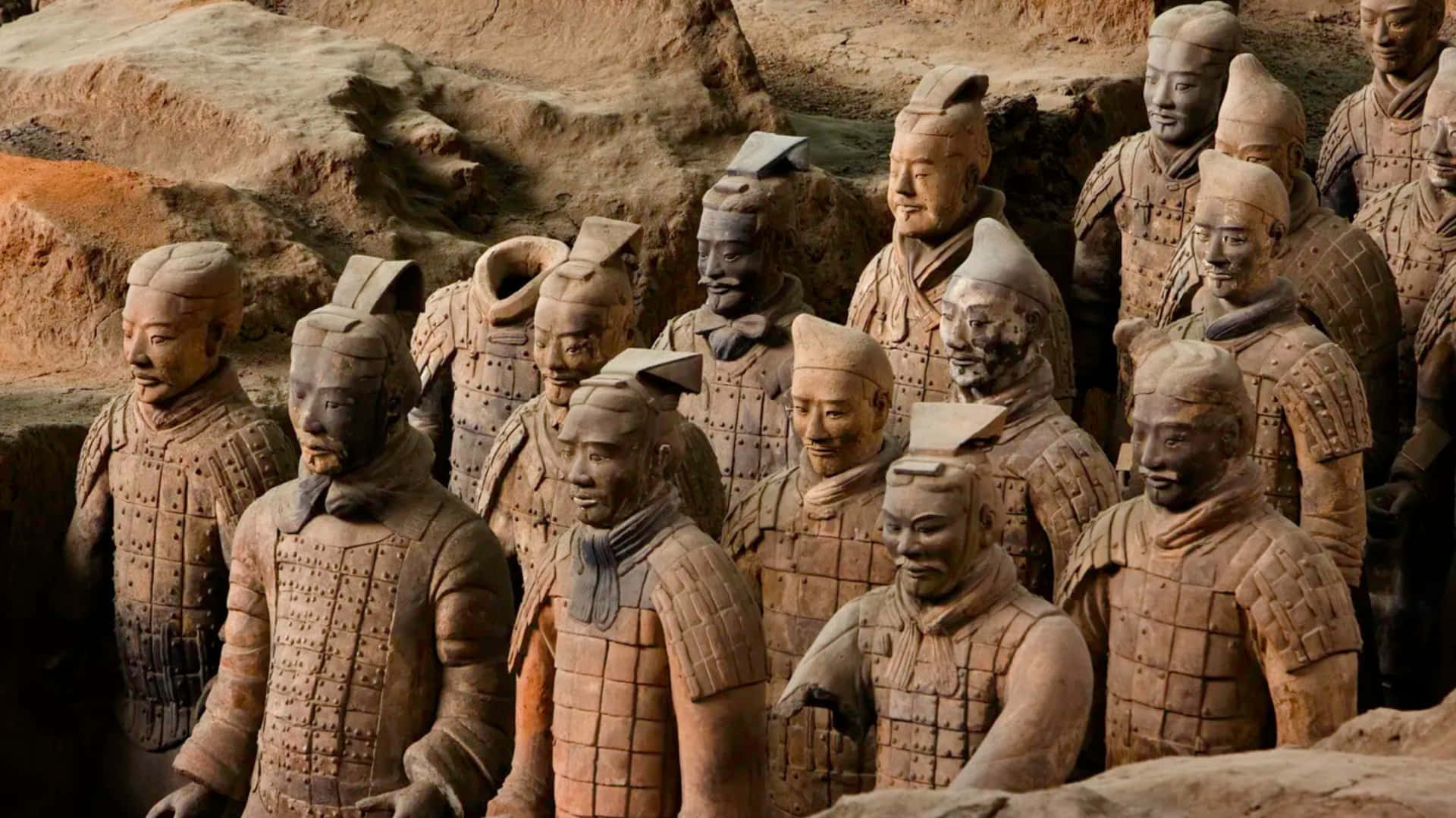  壁紙 — 一排排古老的兵馬俑以大地色調站立，帶有詳細的盔甲和獨特的面部表情，位於他們的發掘坑中。