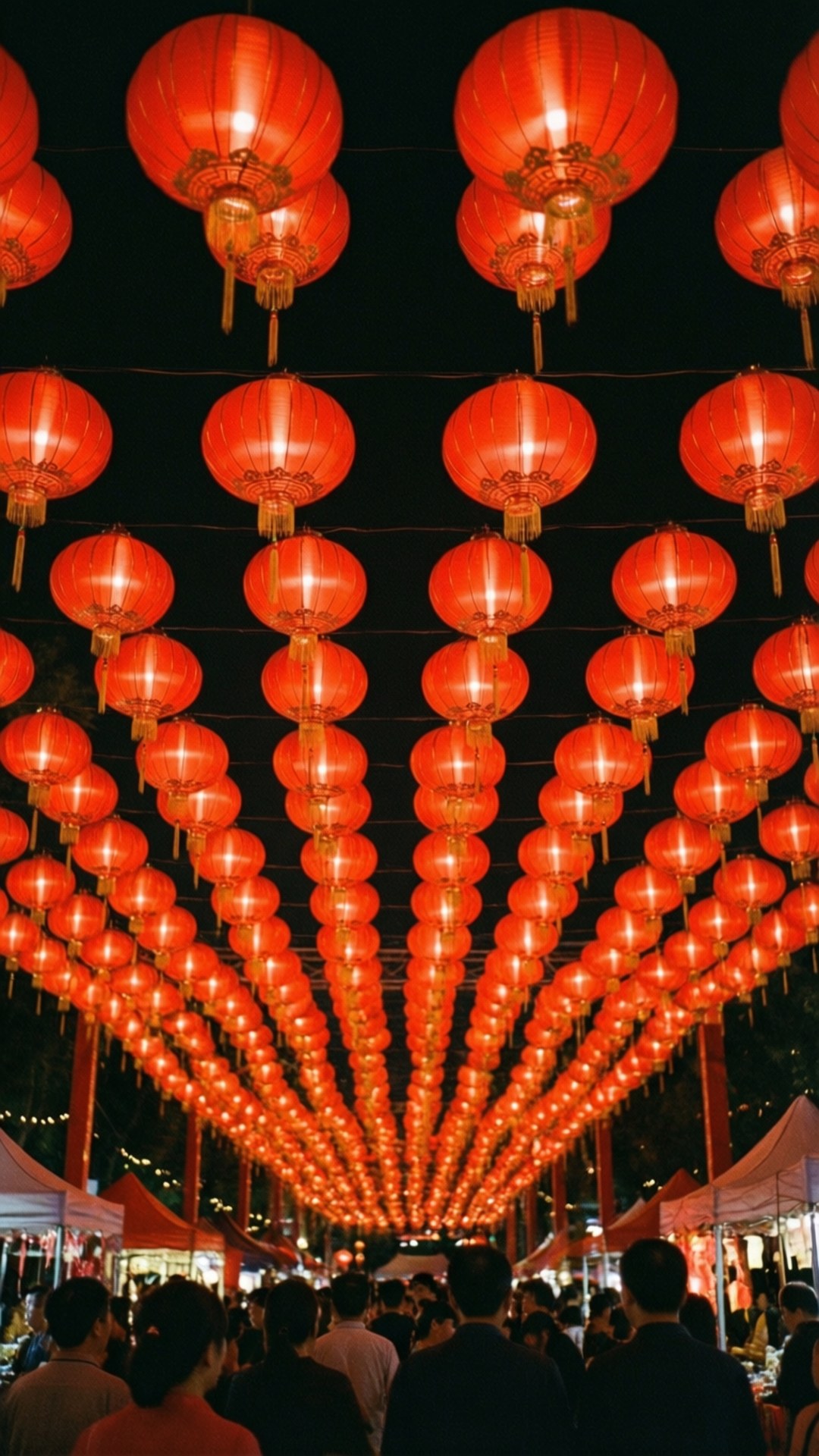 Red Lantern Festival 壁紙 — 一排排發光的紅色燈籠懸掛在頭頂，在繁華的夜市上方形成一個充滿活力的天篷。