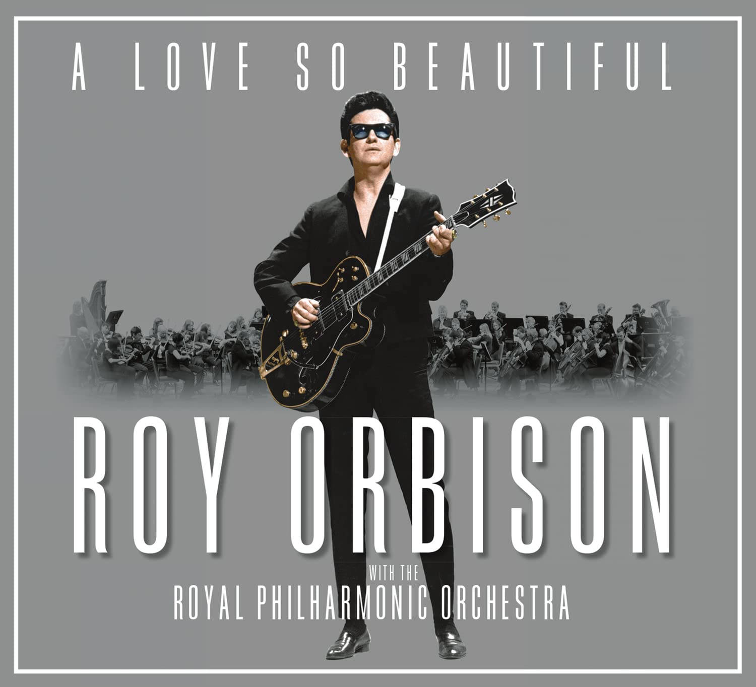 Retro 桌布 壁紙 — Roy Orbison 身穿黑色西裝和太陽眼鏡，在灰色背景前拿著吉他，身後有模糊的樂團。