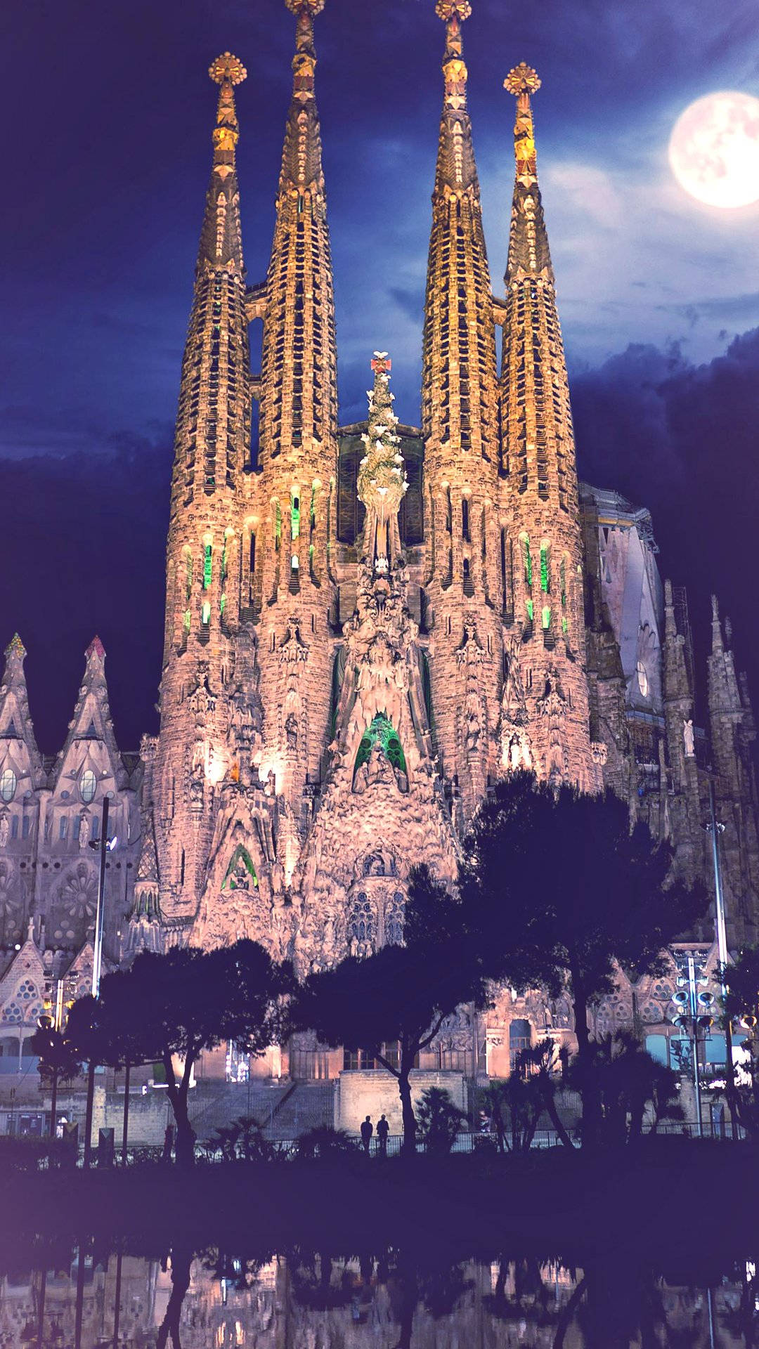Night Sky Moon 桌布 壁紙 — Sacred heart cathedral 在夜間被照亮，滿月在其複雜的尖頂和精緻的外牆上方發光。