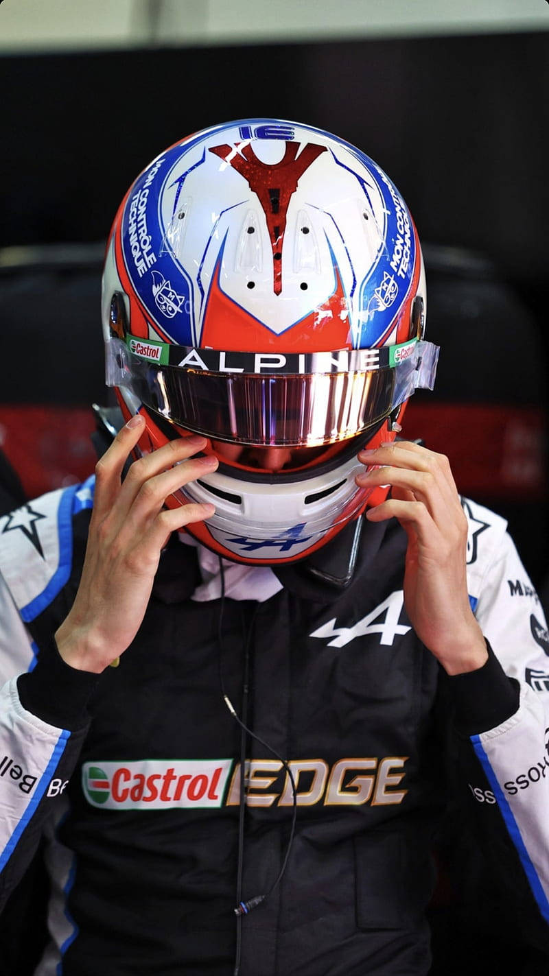 賽車手在賽車服中調整頭盔，帶有贊助商標誌。 — F1手機壁紙 壁紙