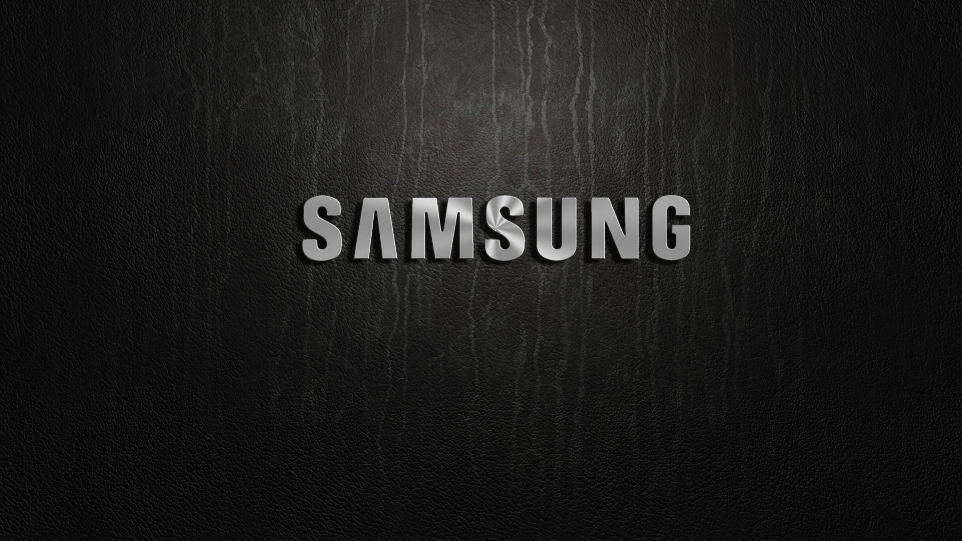 黑色皮革紋理上帶有金屬飾面的 Samsung 標誌。 — 三星 壁紙
