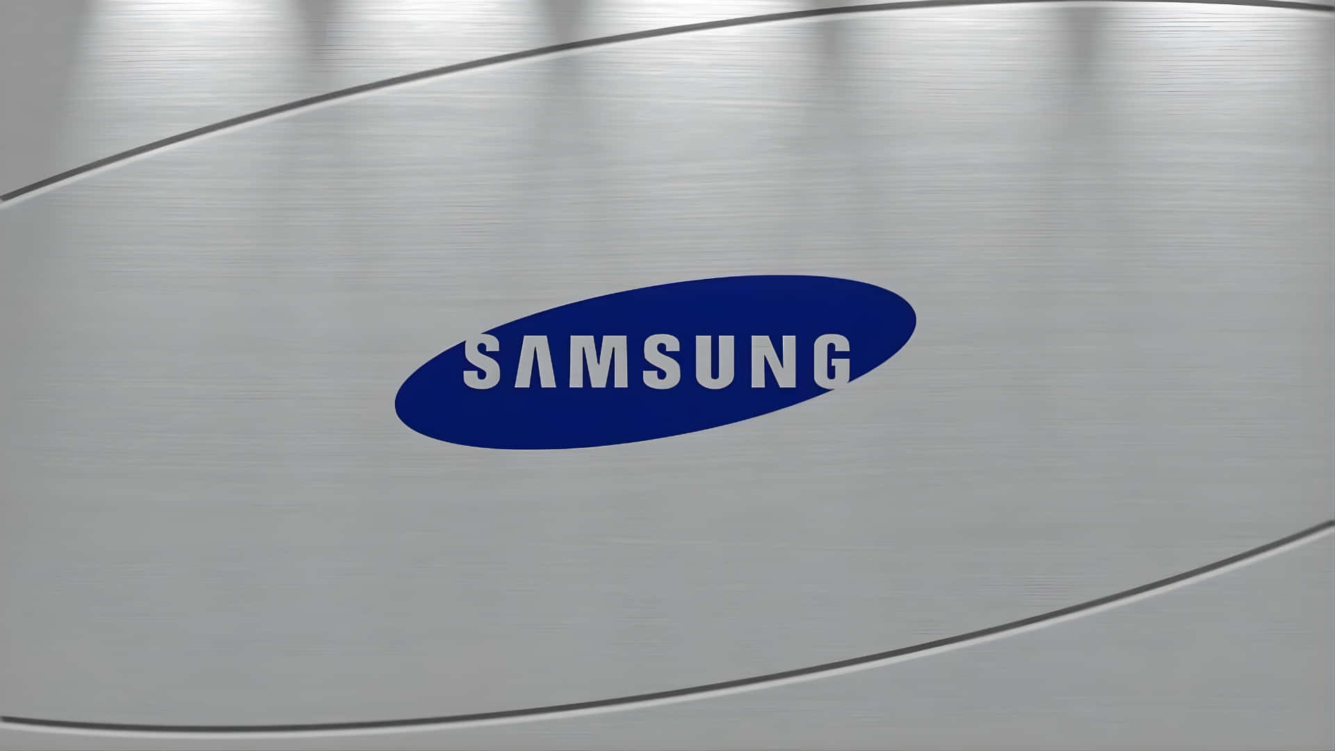  壁紙 — 光滑的拉絲金屬表面中央展示標誌性的藍色Samsung標誌，線條簡潔現代。