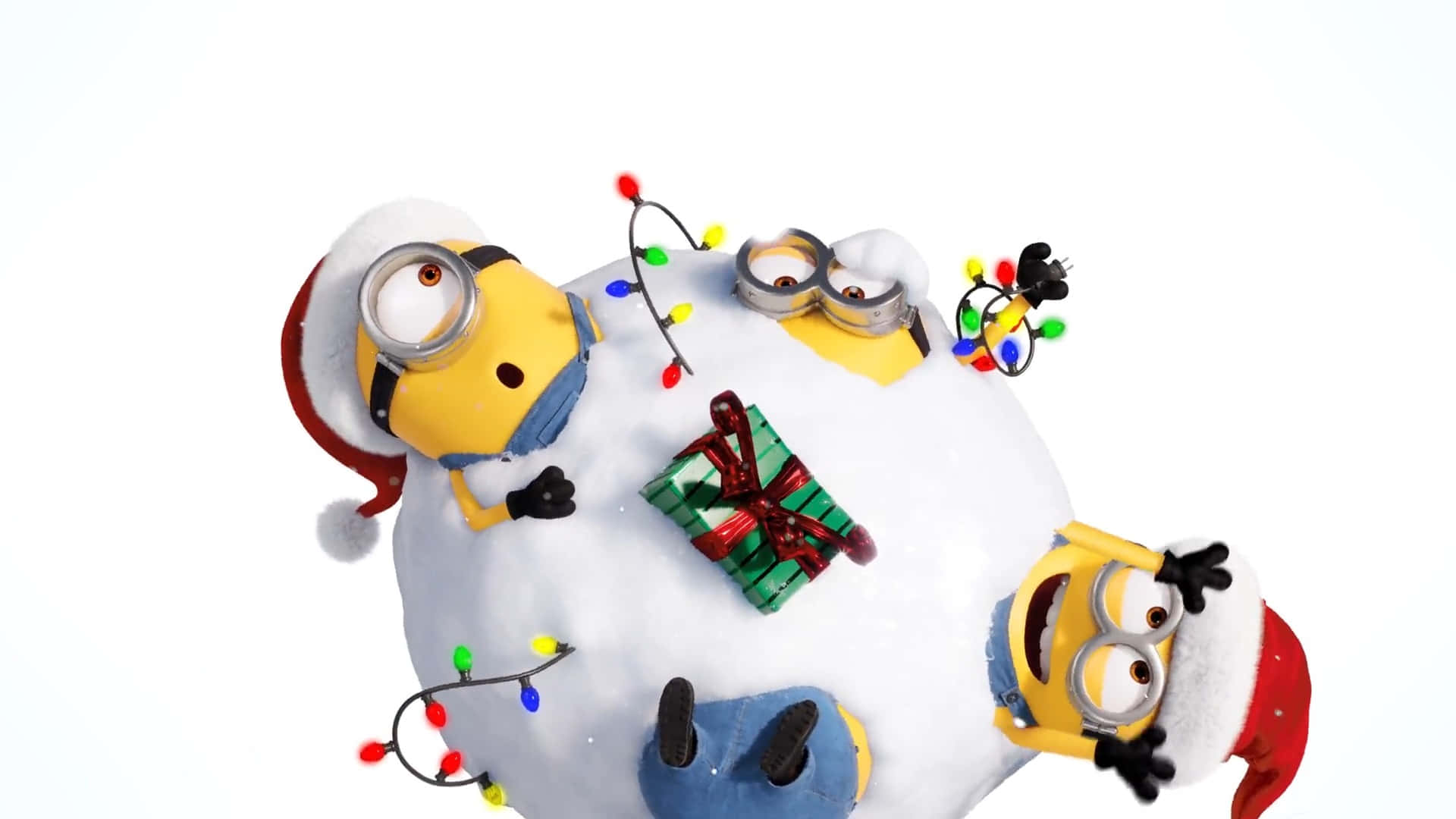  壁紙 — 三個戴聖誕帽的小小兵頑皮地埋在雪球裡，配有聖誕燈飾和禮物。