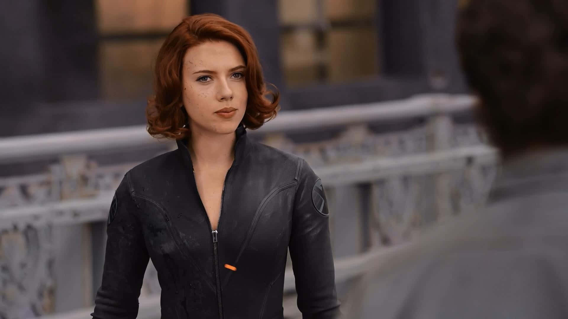 Black Widow 桌布 壁紙 — Scarlet Witch 身處 gritty 城市環境，身穿黑色戰術外套，配有橙色拉鍊細節。