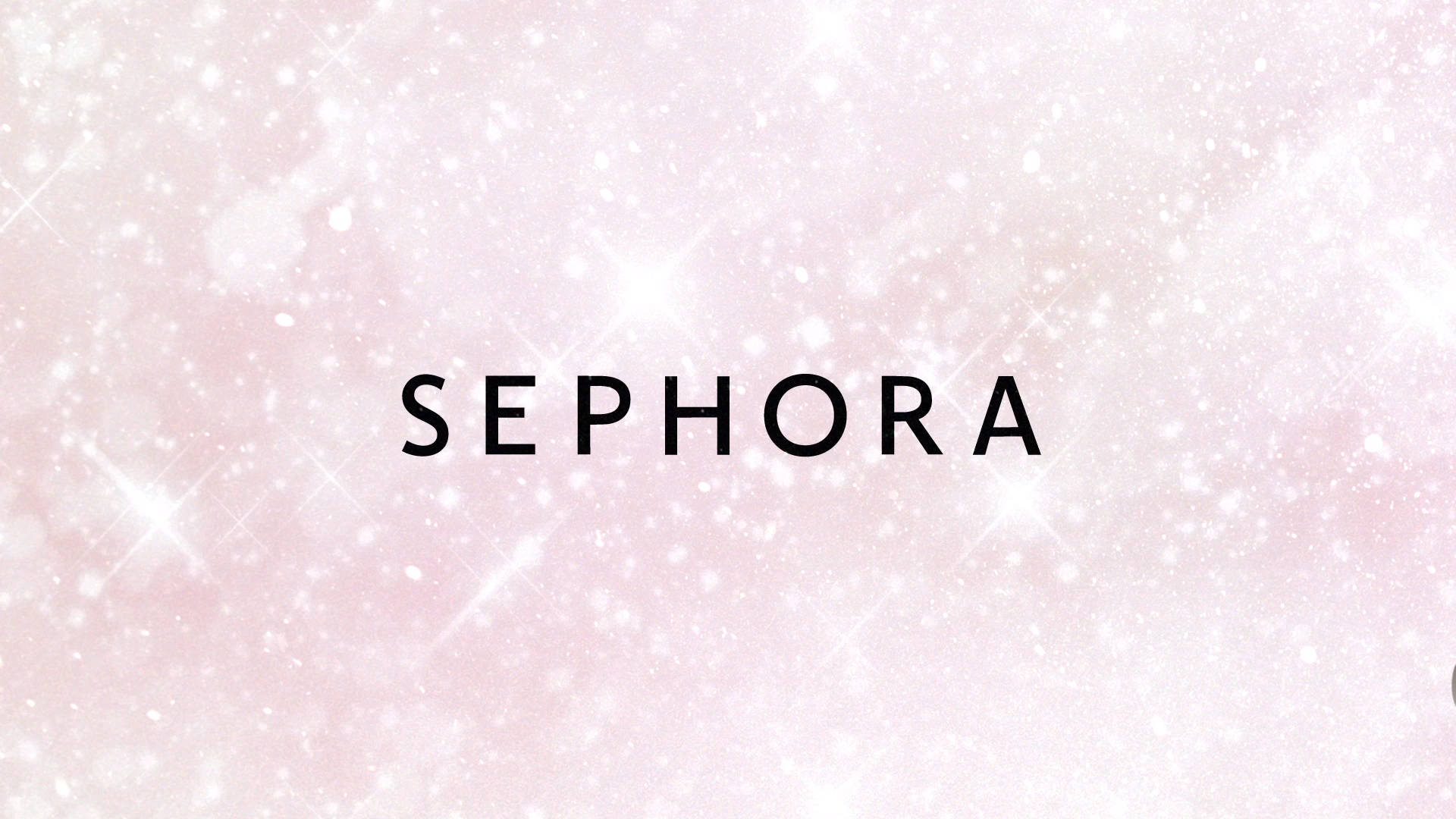 絲芙蘭 桌布 壁紙 — 「Sephora」一詞以粗體黑色字樣，在閃爍著白色星星的柔和粉紅色背景上突出顯示。