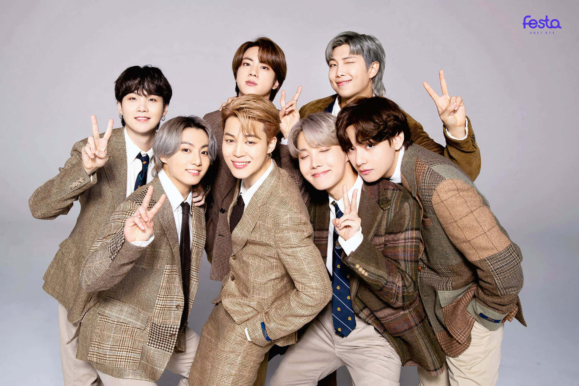 七名身穿格紋西裝的微笑男子在攝影棚中擺出和平手勢。 — Bts 壁紙