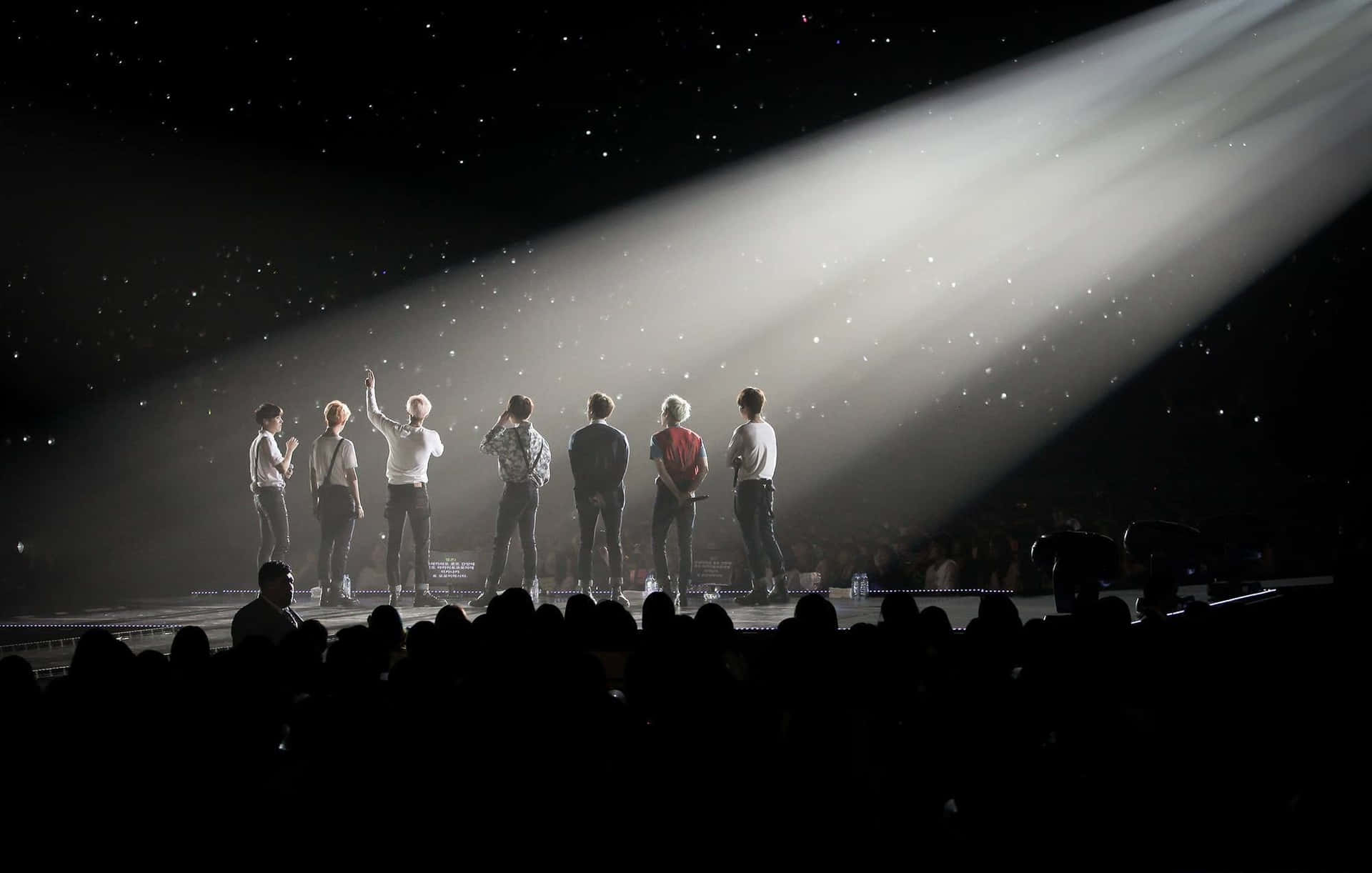 七位表演者在舞台上，聚光燈下，彩紙飄落，星光燦爛的夜空。 — Bts 壁紙