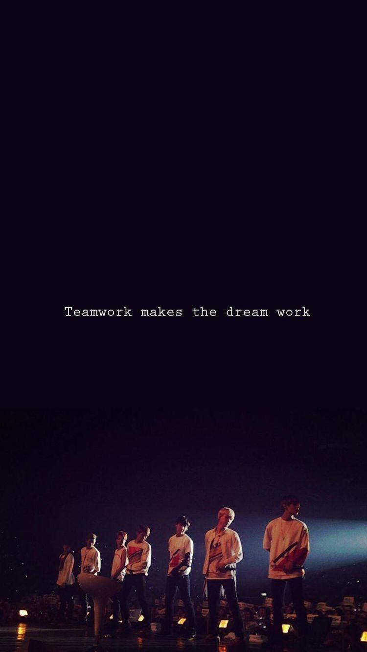 七位音樂家在黑暗的舞台上，有聚光燈和文字「teamwork makes the dream work」。 — Bts 壁紙