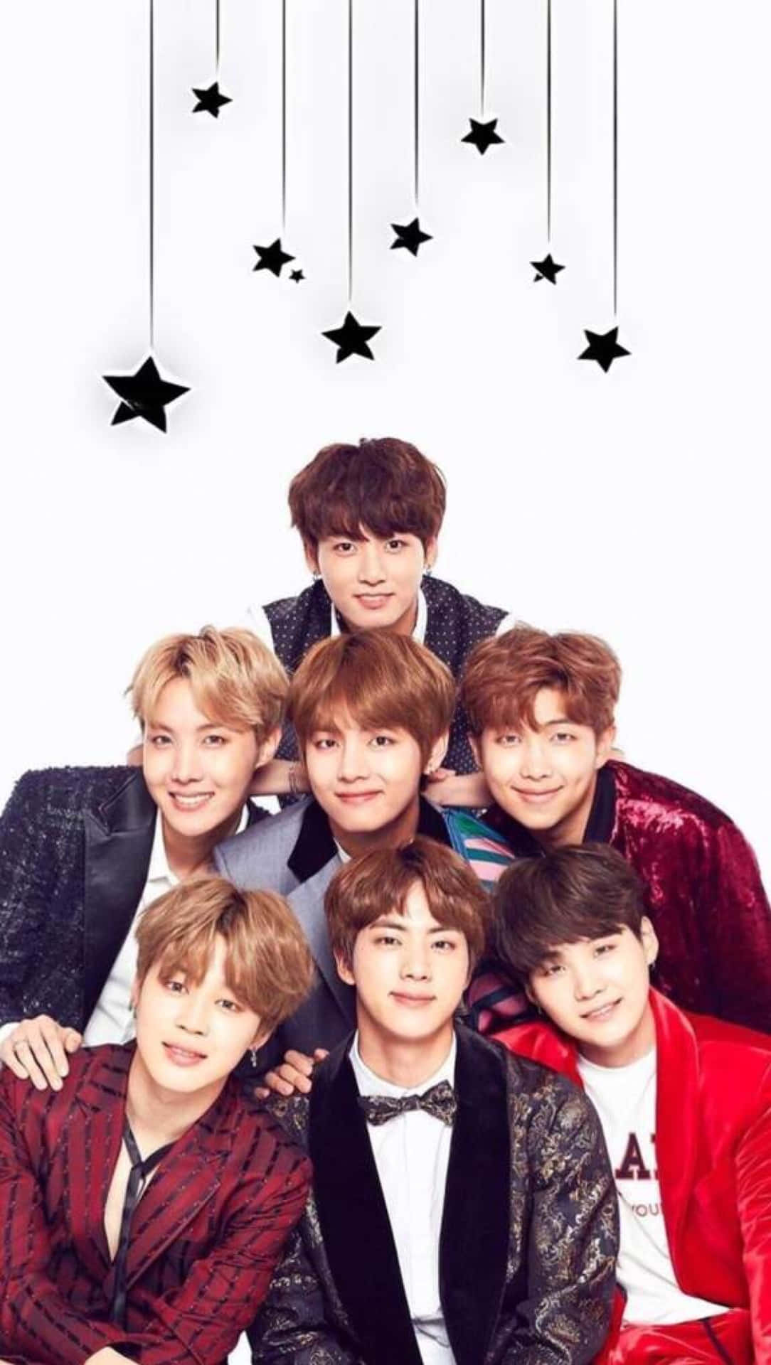 七位K-pop偶像身著正裝在懸掛的星星下微笑。 — Bts 壁紙
