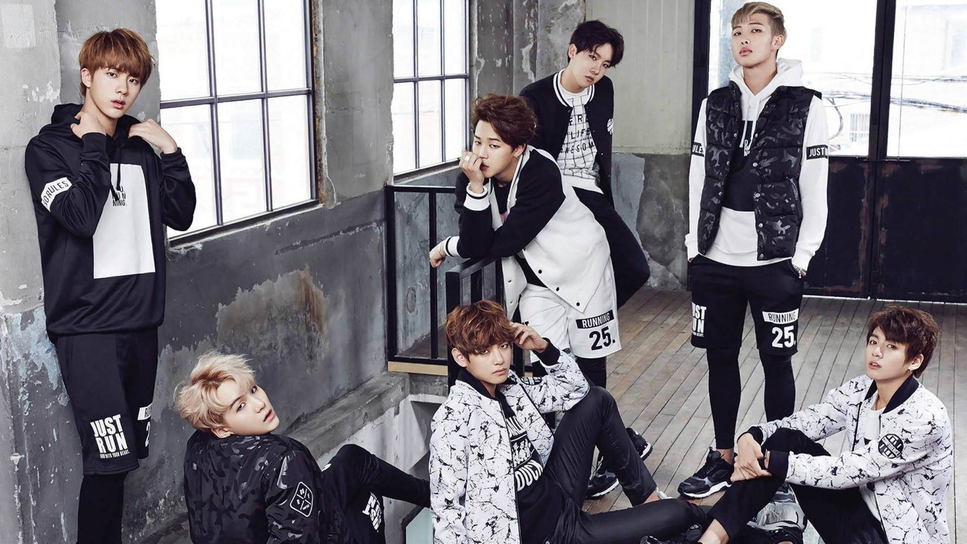 七位時尚年輕男士在現代工業風閣樓中身穿黑白運動服擺姿勢。 — Bts 壁紙