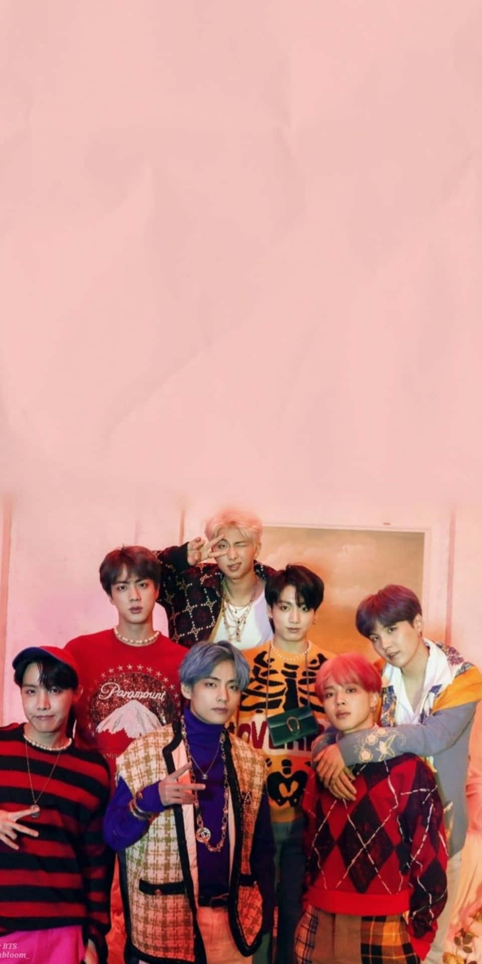 七位時尚年輕男士身穿色彩繽紛的服裝在粉紅色牆前擺姿勢。 — Bts 壁紙