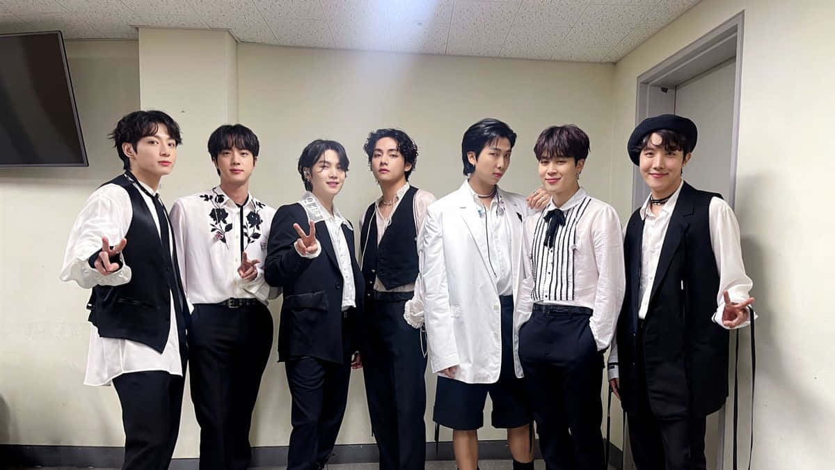 七位時尚男士穿著黑白服裝在室內擺姿勢。 — Bts 壁紙