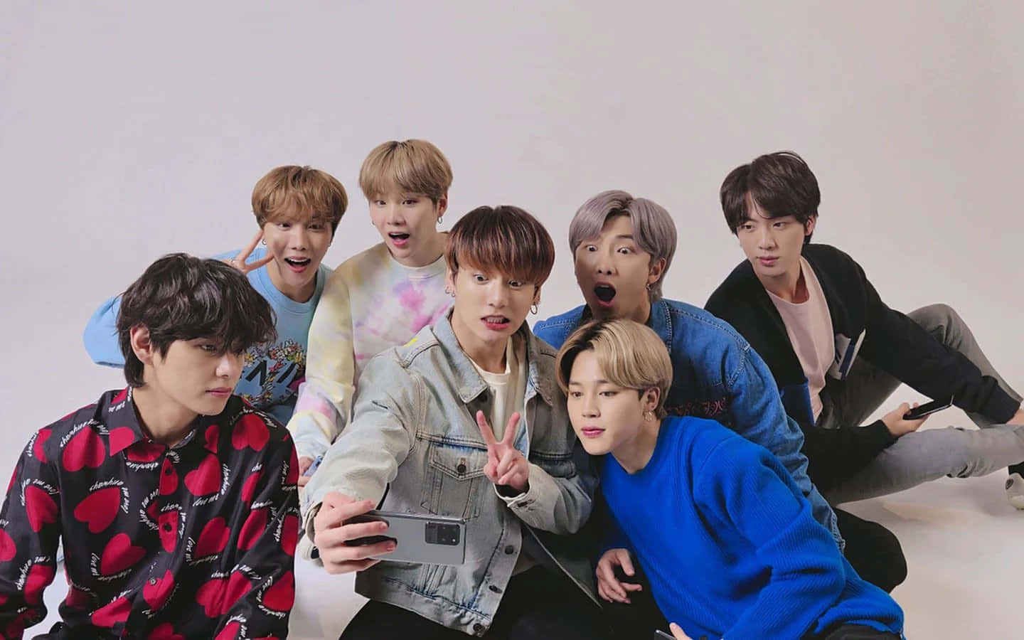 七位年輕男子穿著休閒服裝在攝影棚內擺姿勢自拍。 — Bts 壁紙