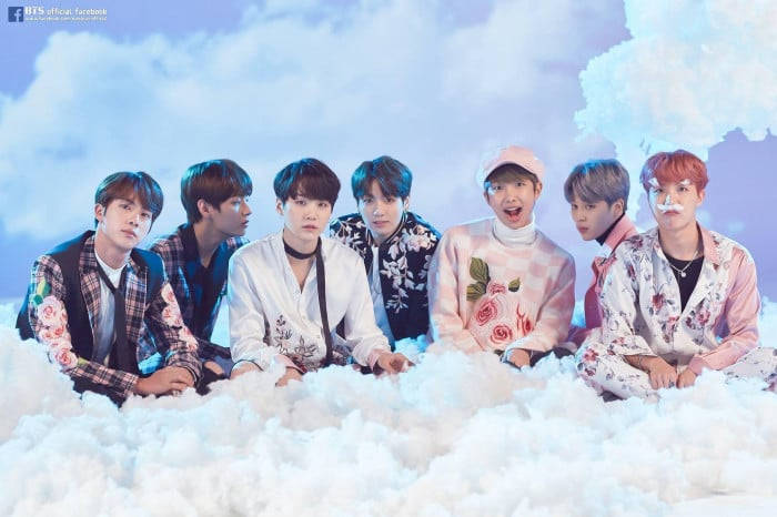 七位身穿花卉服裝的K-pop偶像坐在雲上，背景是柔和藍天。 — Bts 壁紙