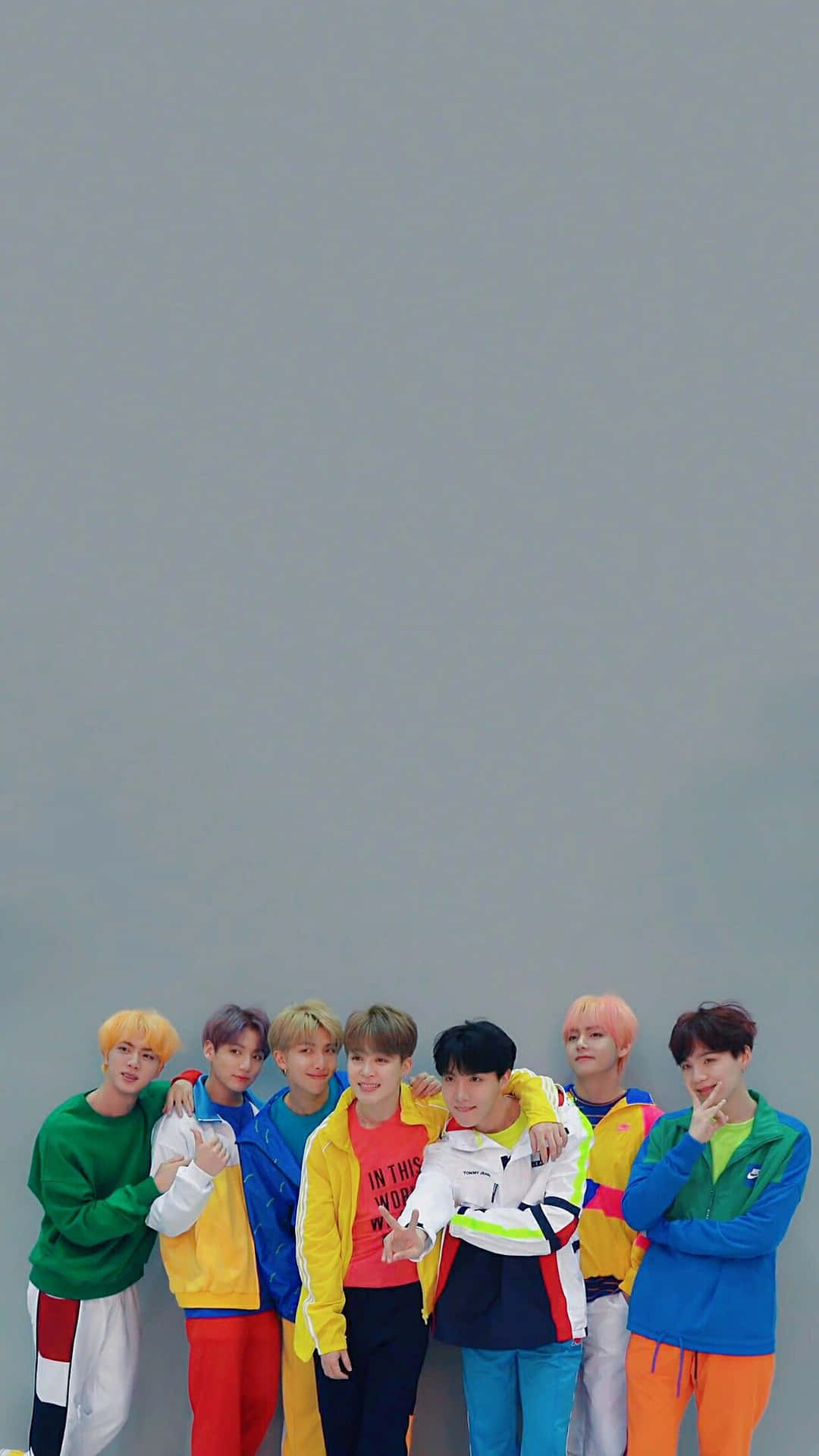 七位穿著亮眼服裝的時尚年輕男性微笑著一起擺姿勢。 — Bts 壁紙