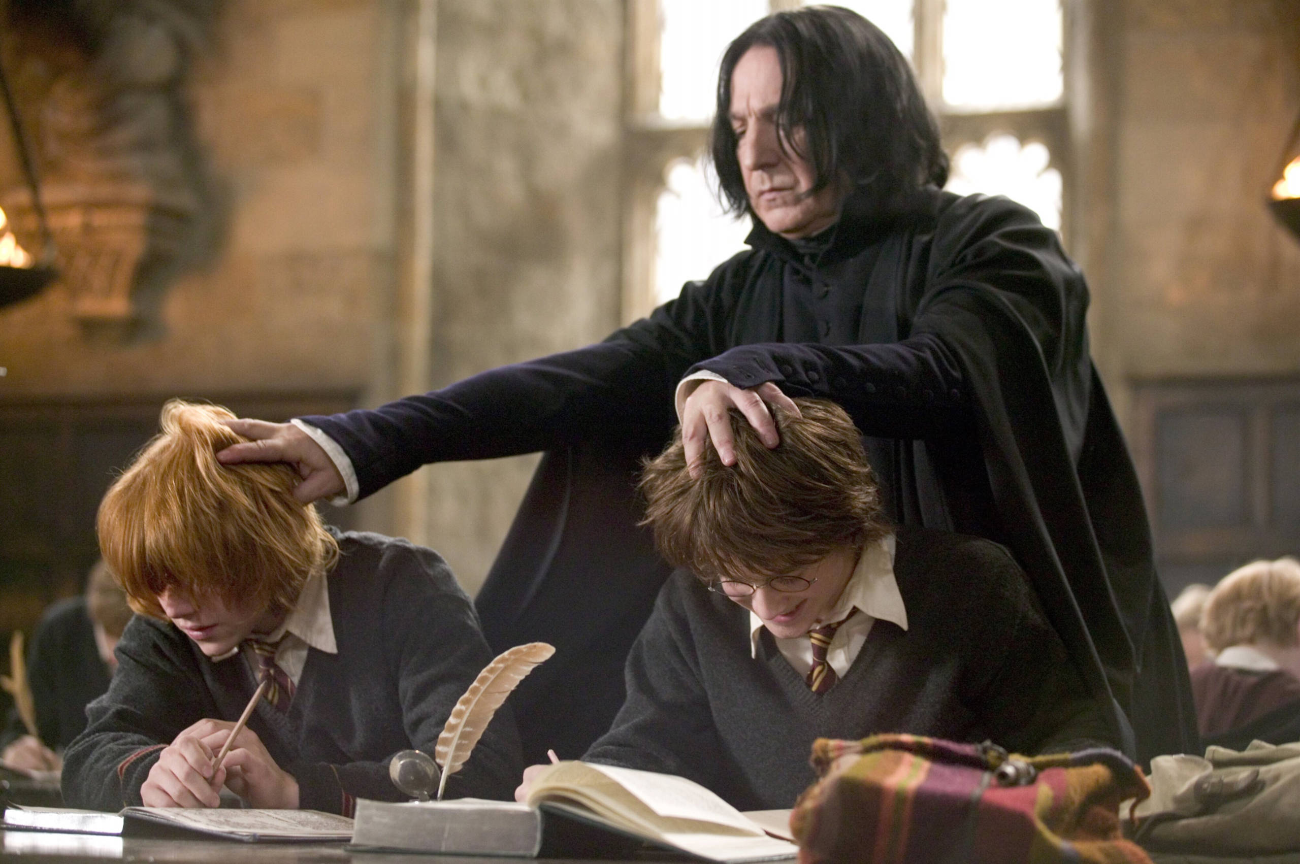 Severus Snape 桌布 壁紙 — Severus Snape 嚴厲地調整哈利波特和榮恩衛斯理的頭髮，而他們正在霍格華茲課堂上寫字。