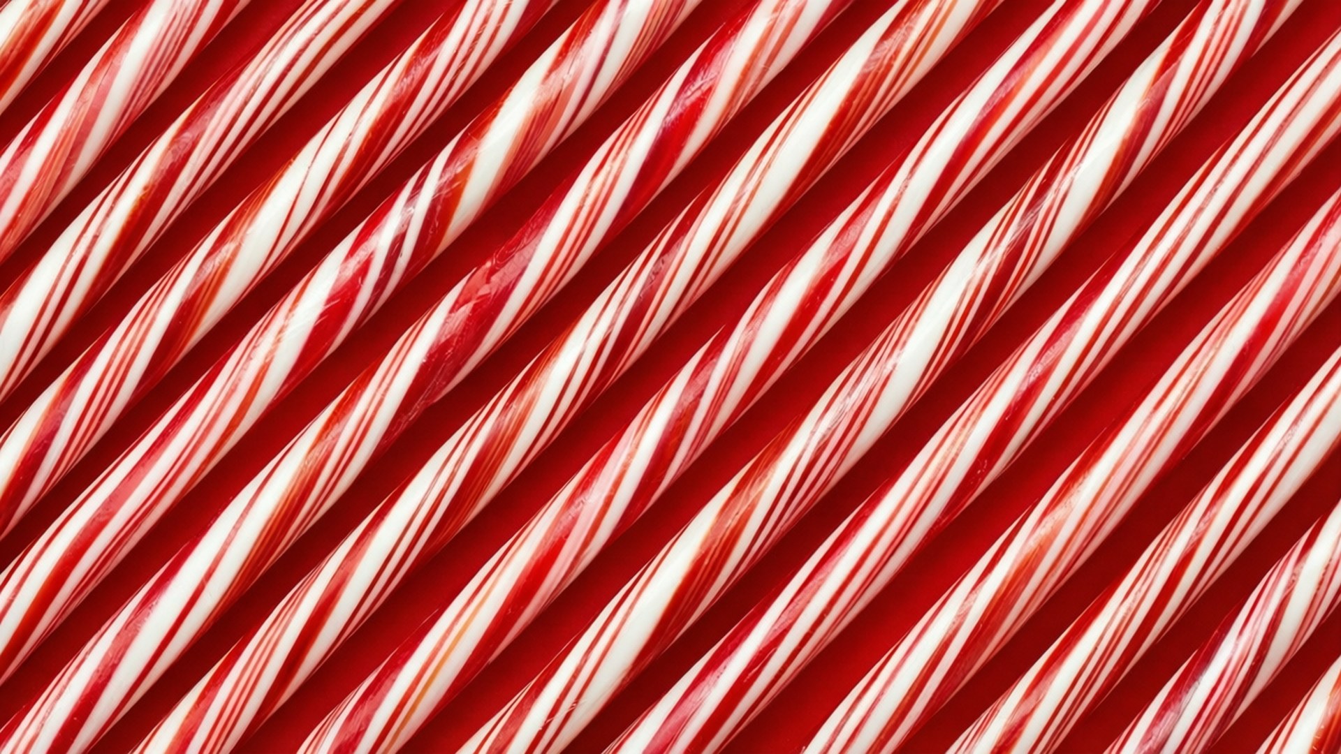 Candy Cane Red White Stripes 壁紙 — 閃亮的紅白條紋拐杖糖以對角線排列，營造出充滿活力的節日圖案。