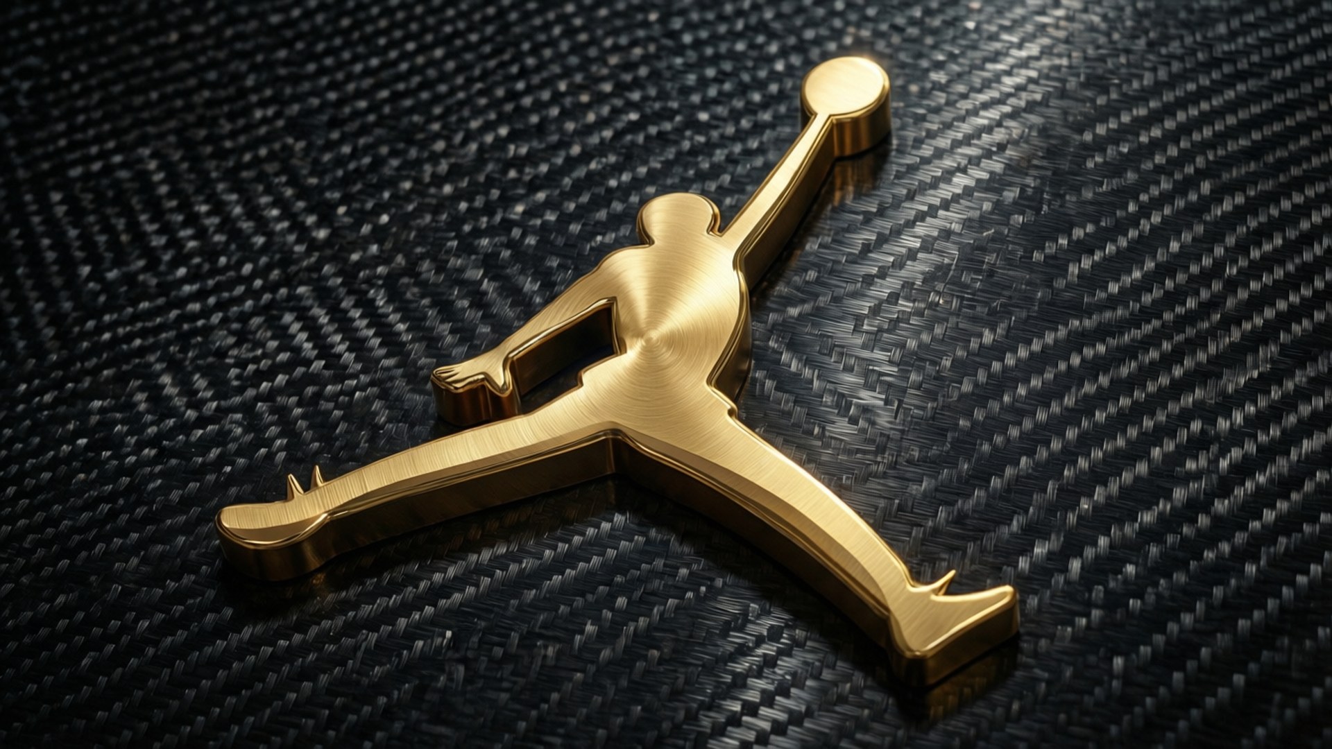 金色 Jumpman 標誌在黑色碳纖維背景上 — Jordan Logo 壁紙