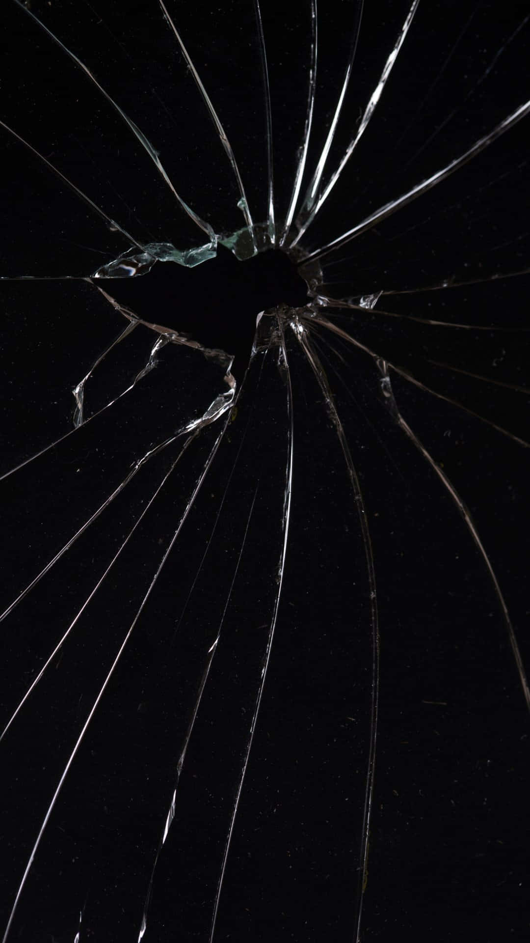  壁紙 — 一塊破碎的玻璃表面，從中央撞擊點向外輻射出放射狀裂紋，背景為黑色。