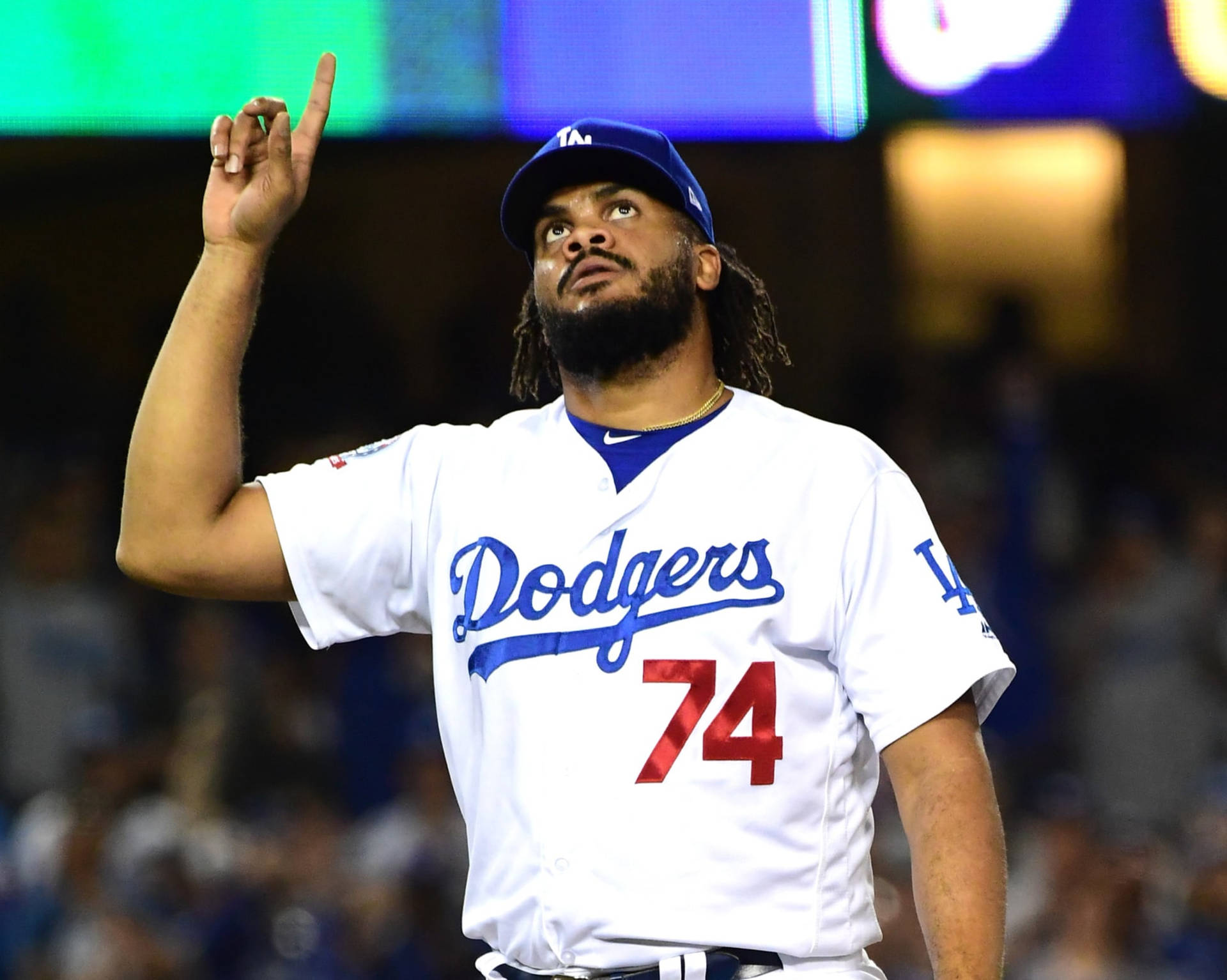 道奇隊棒球選手在夜間比賽中向上指。 — MLB 壁紙