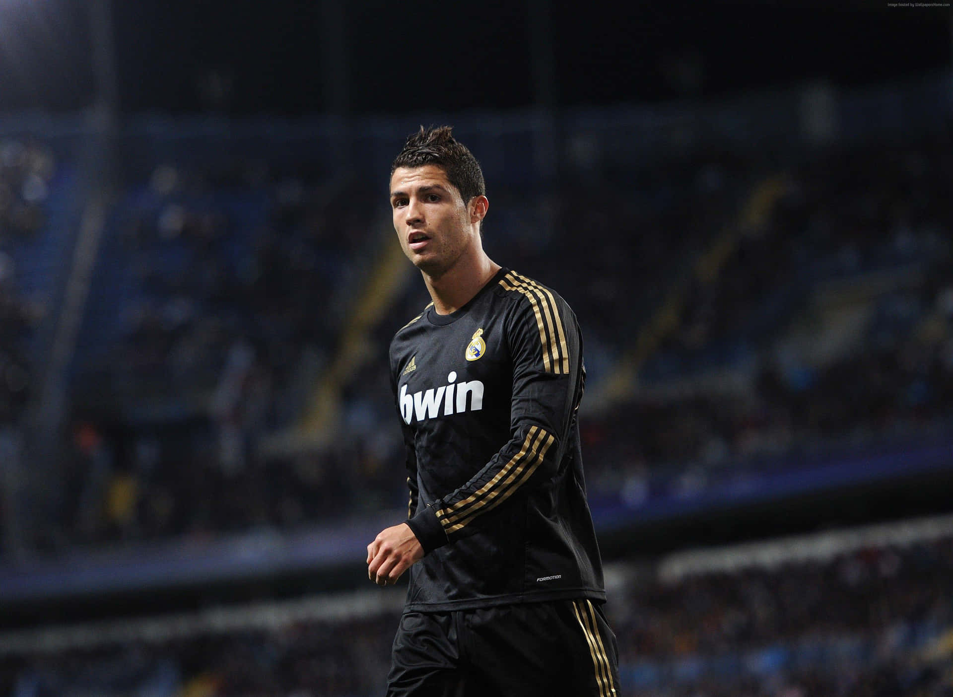 基斯坦奴·朗拿度身穿黑色皇家馬德里球衣在夜間足球場上。 — Cristiano Ronaldo 足球 壁紙