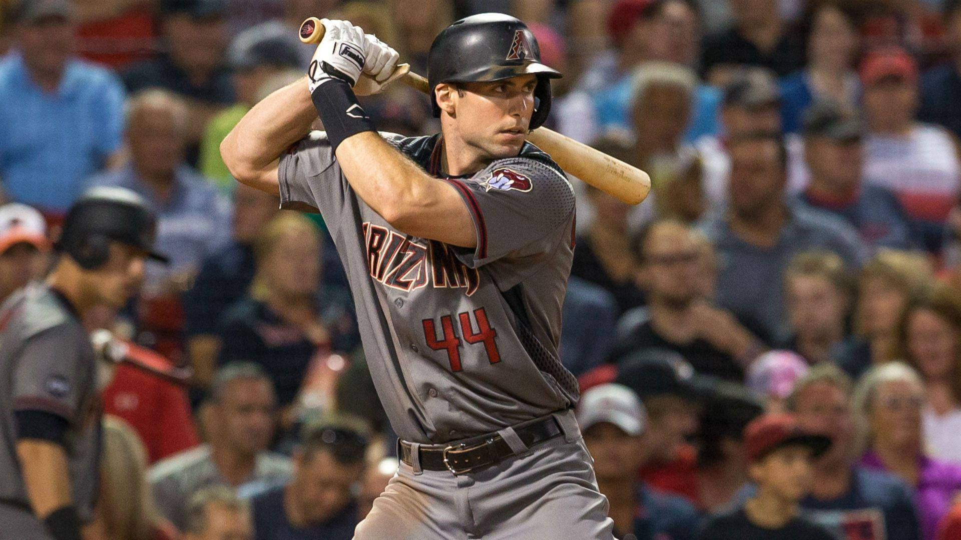 棒球選手在夜間比賽中揮棒，背景有觀眾。 — MLB 壁紙