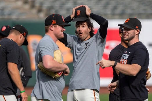 棒球運動員在陽光明媚的球場上穿著巨人隊裝備慶祝。 — MLB 壁紙