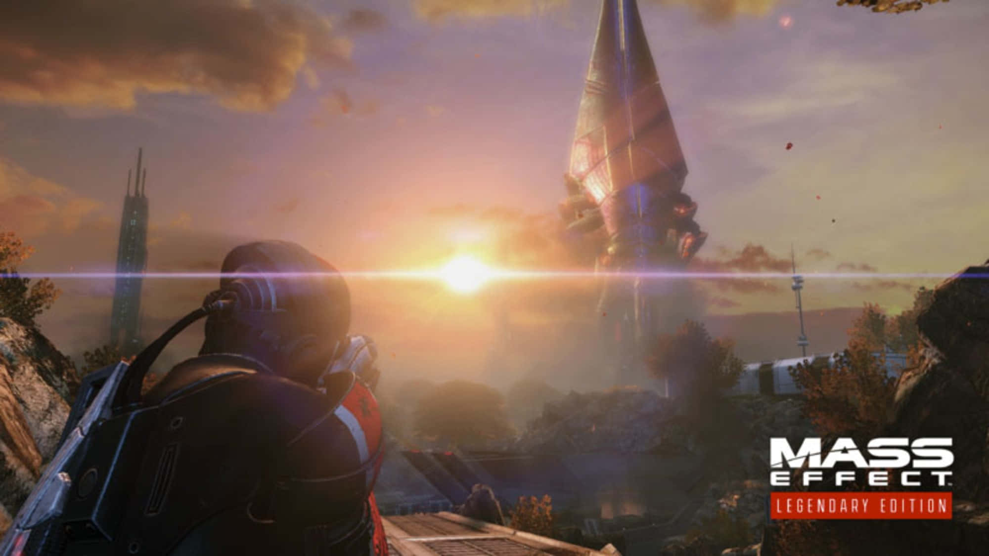 Mass Effect Legendary Edition 桌布 壁紙 — 一名身穿未來裝甲的士兵凝視著一座高聳的外星建築，夕陽在其後落下，將溫暖的金色光芒灑在外星景觀上。