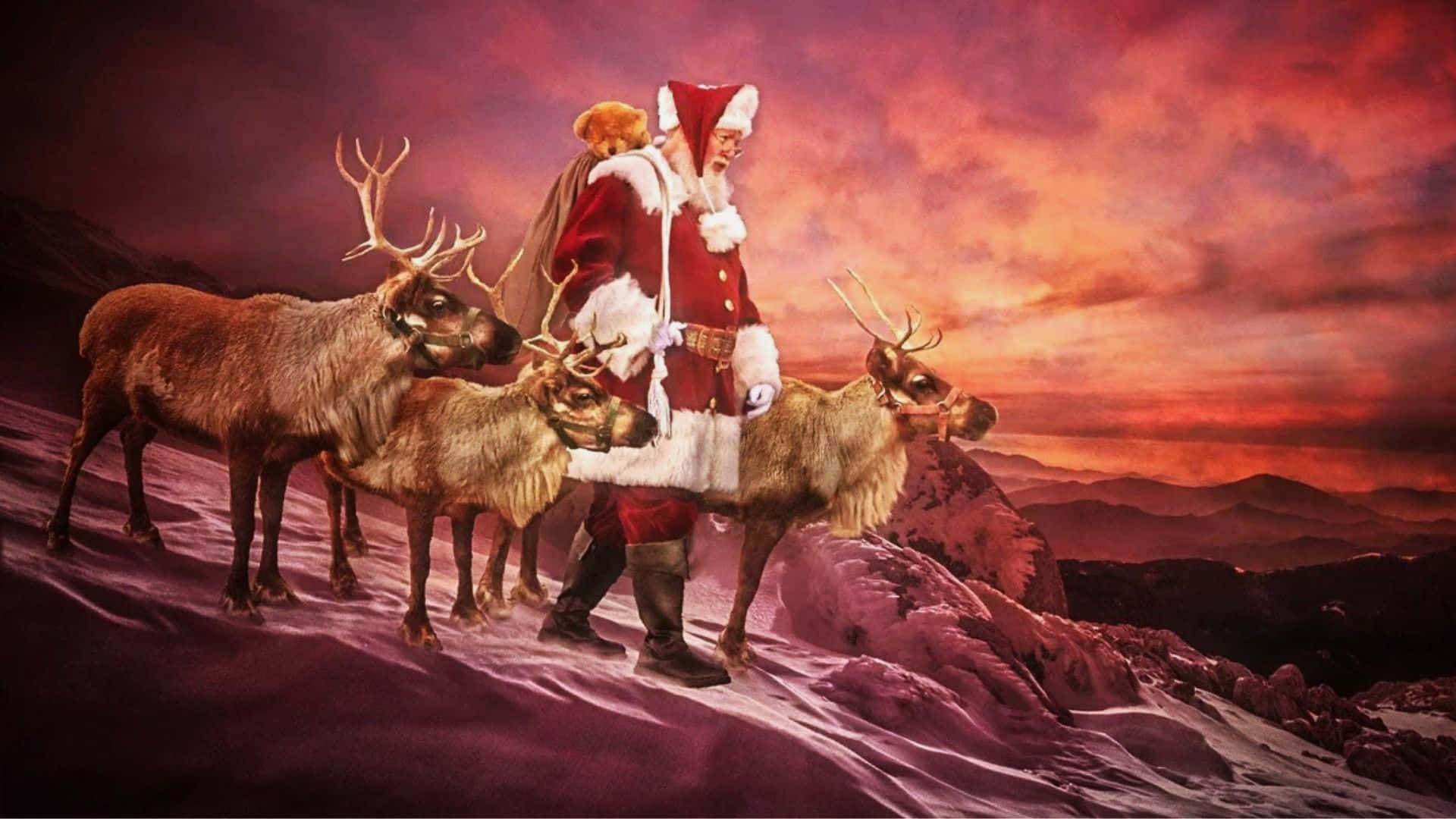  壁紙 — 聖誕老人與三隻馴鹿在火紅和橙色的日落天空下，走過白雪覆蓋的山脊。