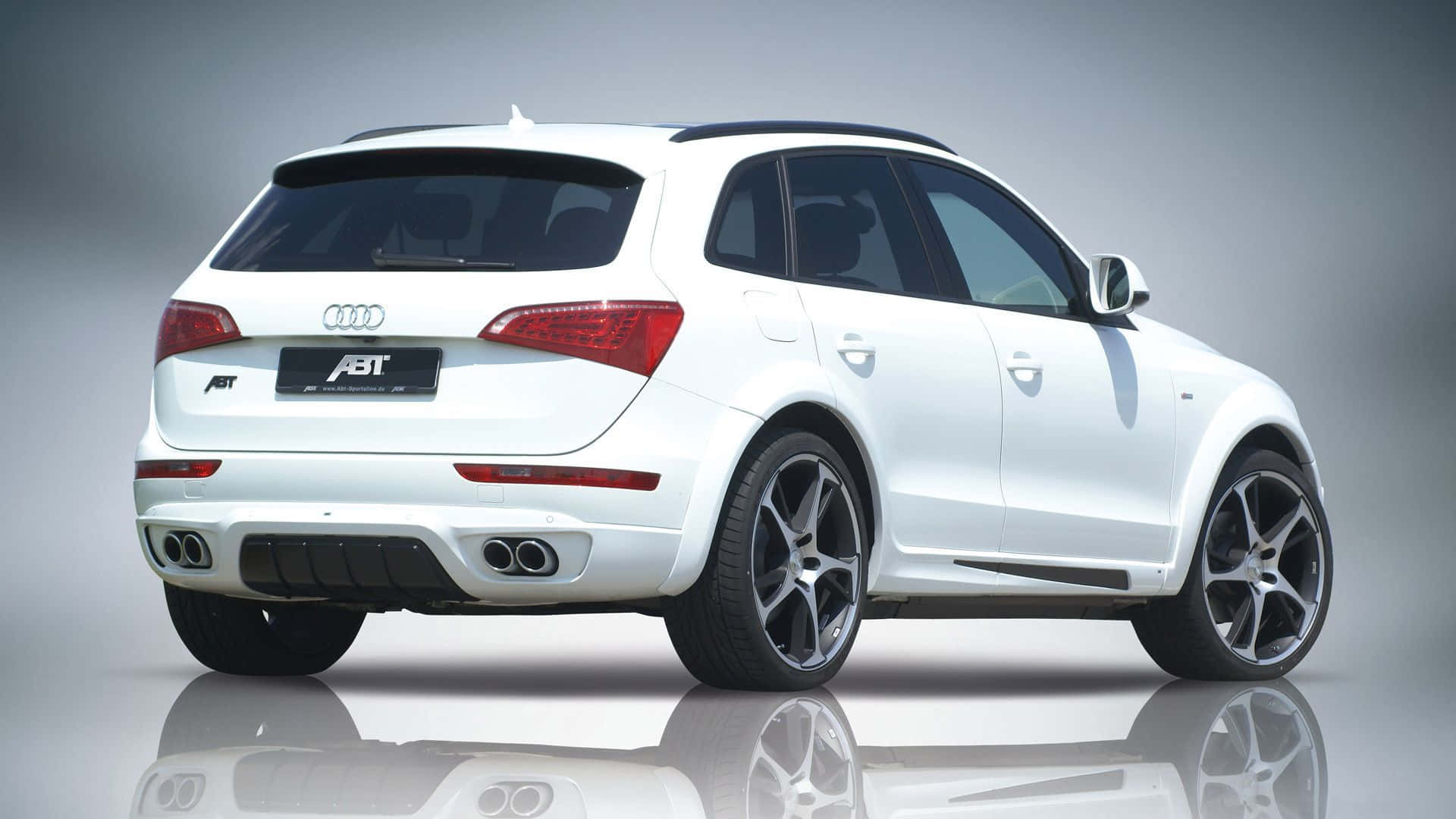Audi Q5 桌布 壁紙 — 一輛時尚的白色ABT改裝奧迪Q5 SUV，在攝影棚中展示，帶有光澤反射和運動型黑色輪圈。