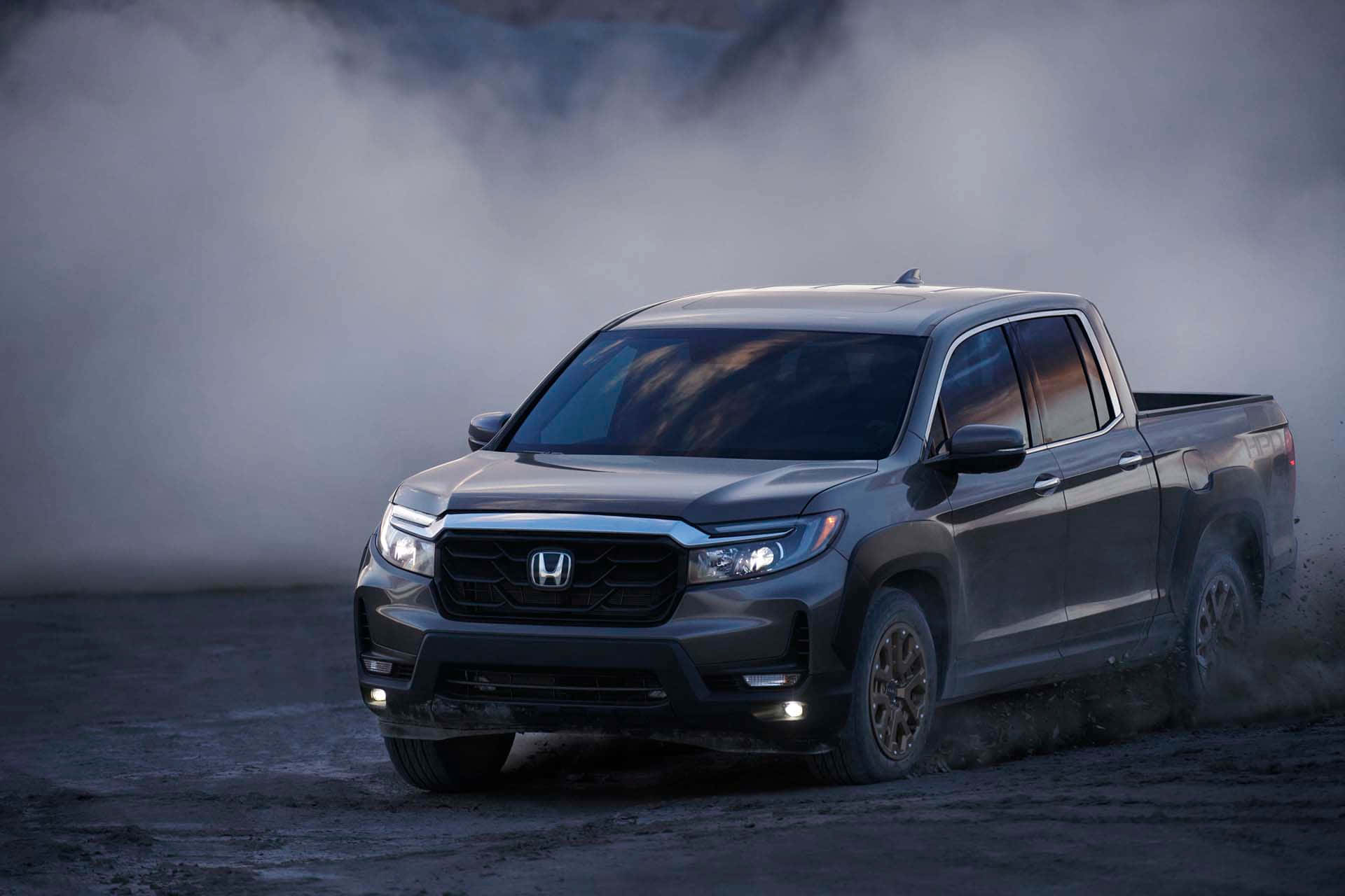 Honda Ridgeline 桌布 壁紙 — 一輛時尚的灰色本田Ridgeline皮卡車在塵土飛揚的地形上行駛，身後煙霧滾滾。