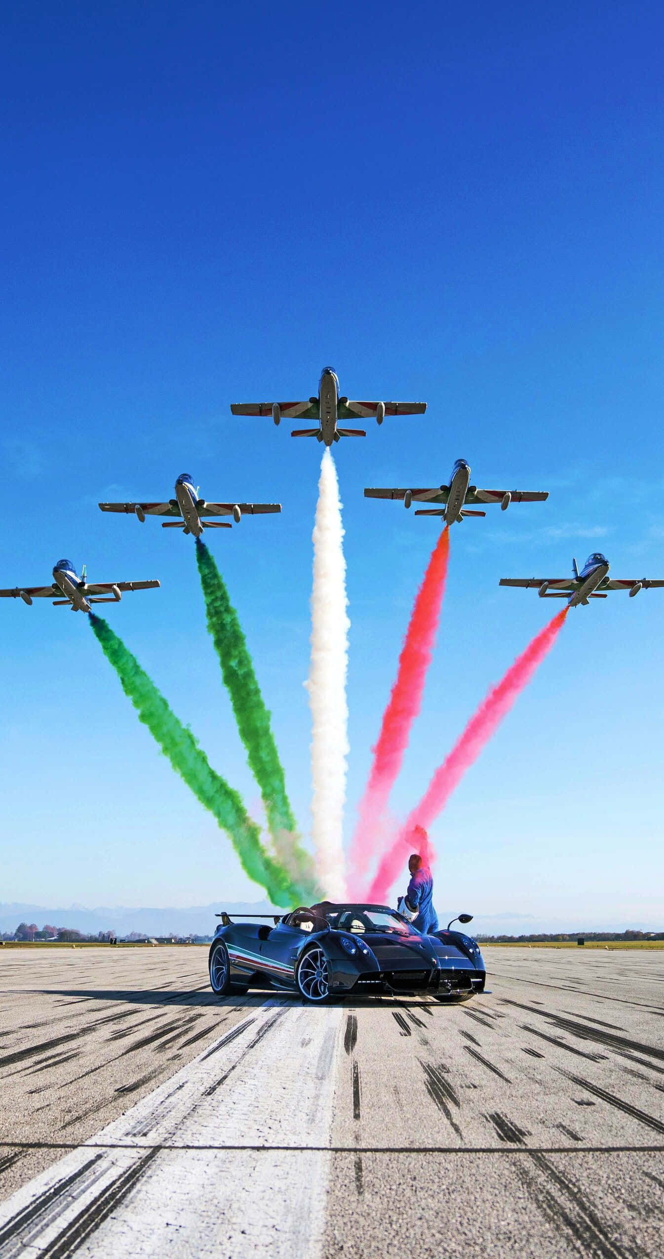 Pagani Zonda Tricolore 桌布 壁紙 — 一輛時尚的藍色跑車在跑道上，四架噴射機在上空飛過，留下綠色、白色和紅色的煙霧，形成義大利國旗。